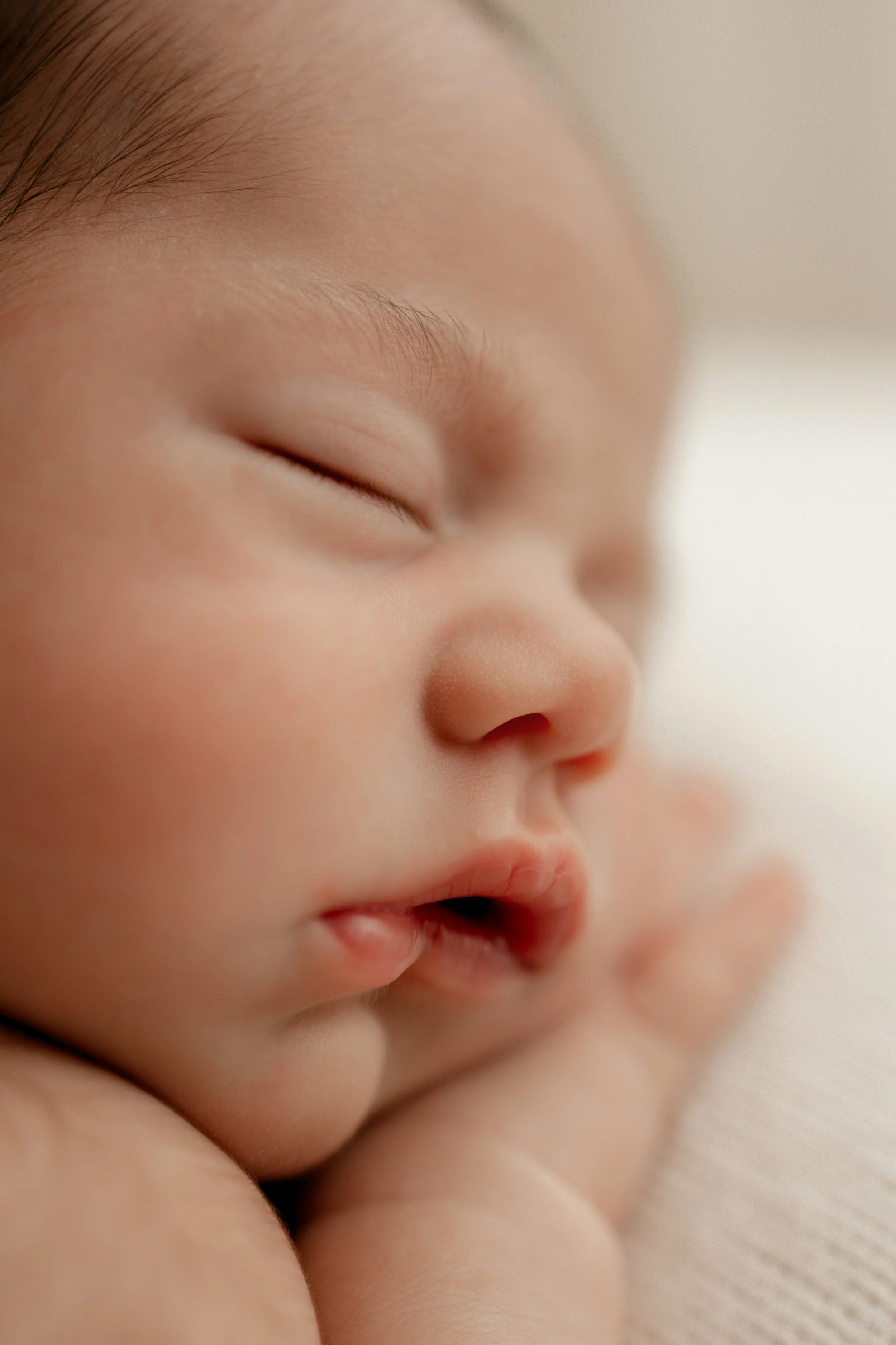 close up of newborn lashes, eyebrows and lips. side profile of newborn