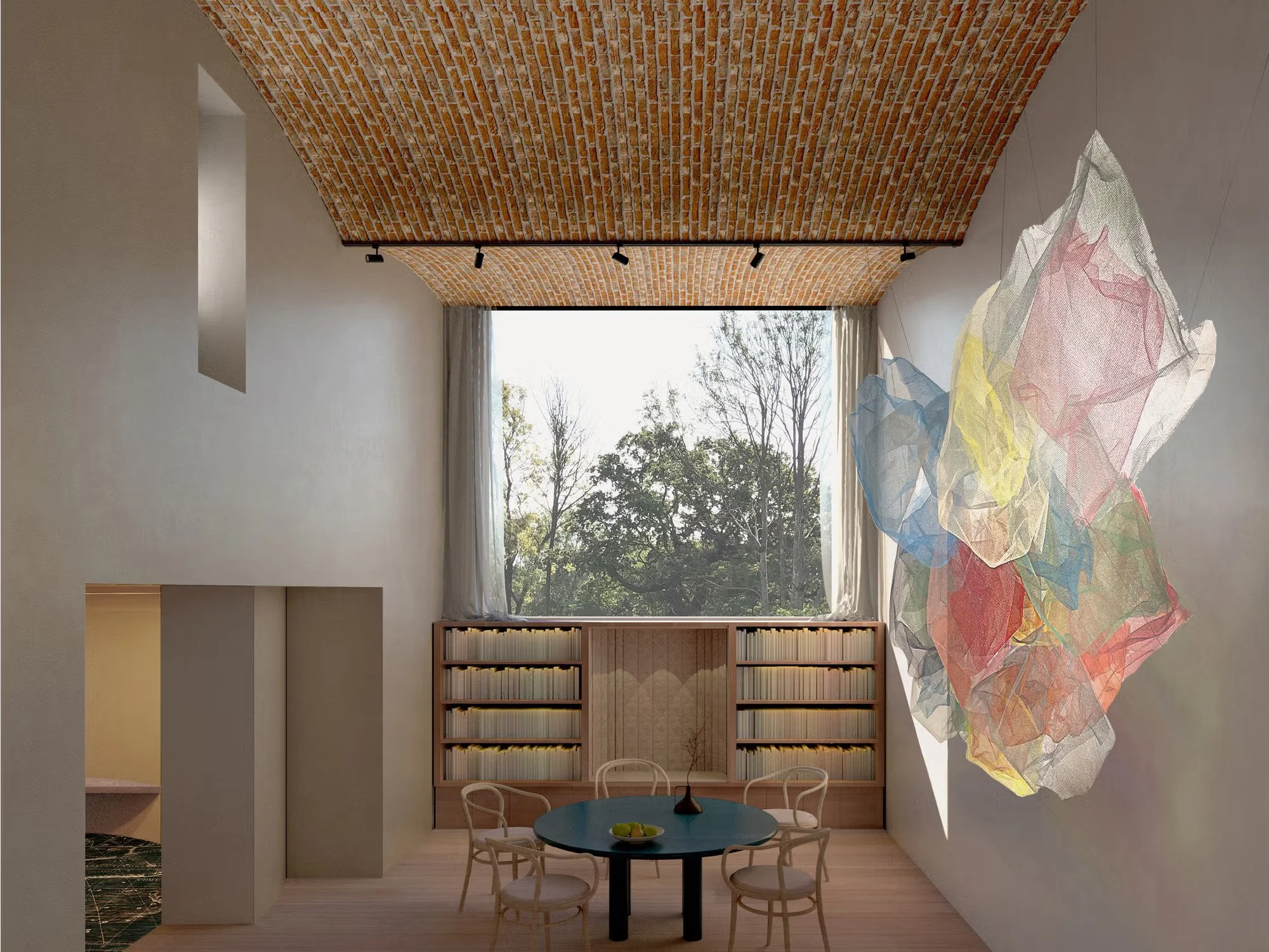 Interior view of a studio with high ceilings and large window overlooking the natural setting.