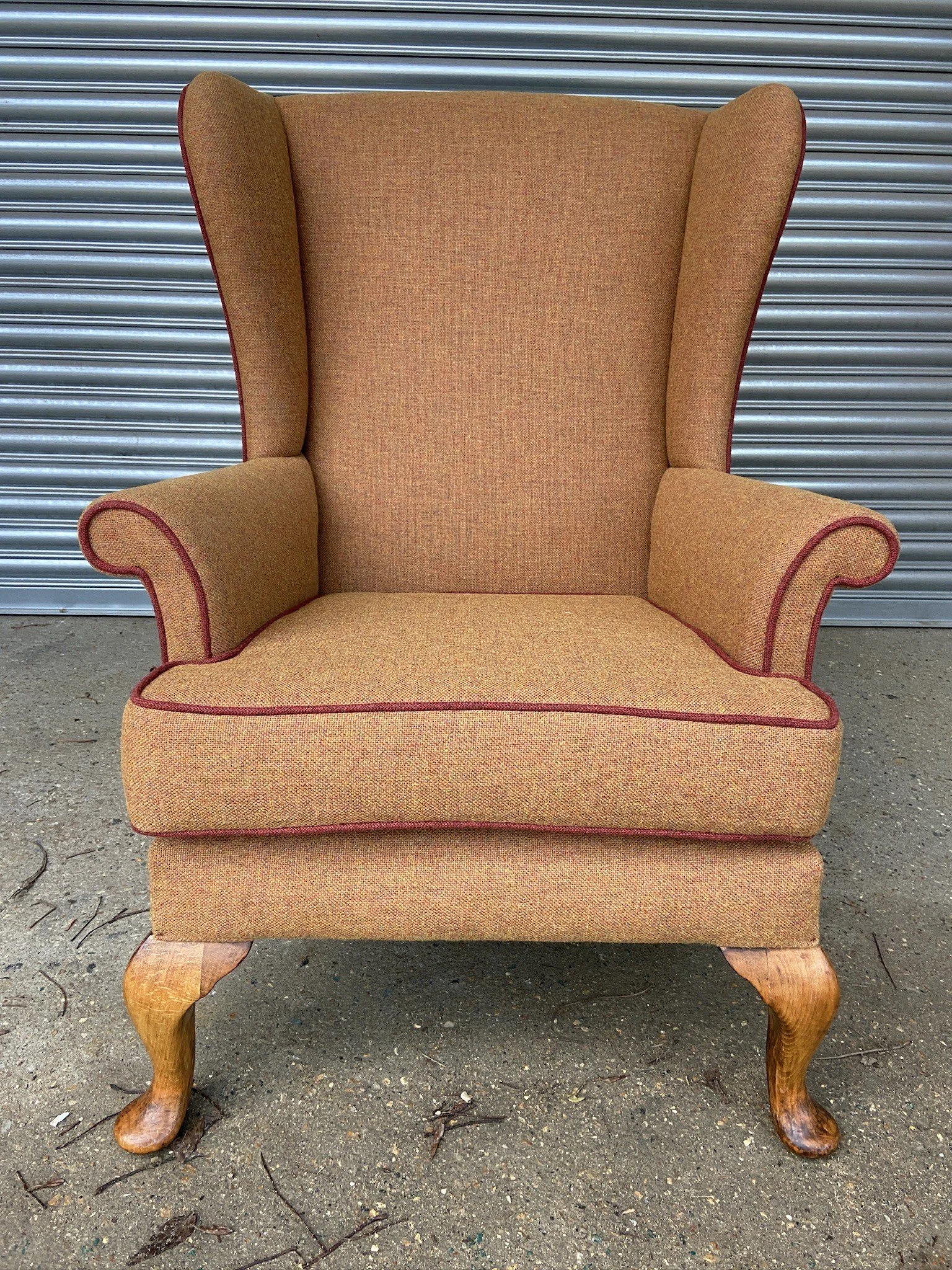 Fully Reupholstered Parker Knoll Wingback in Orange tweed wool with contrasting piping. 