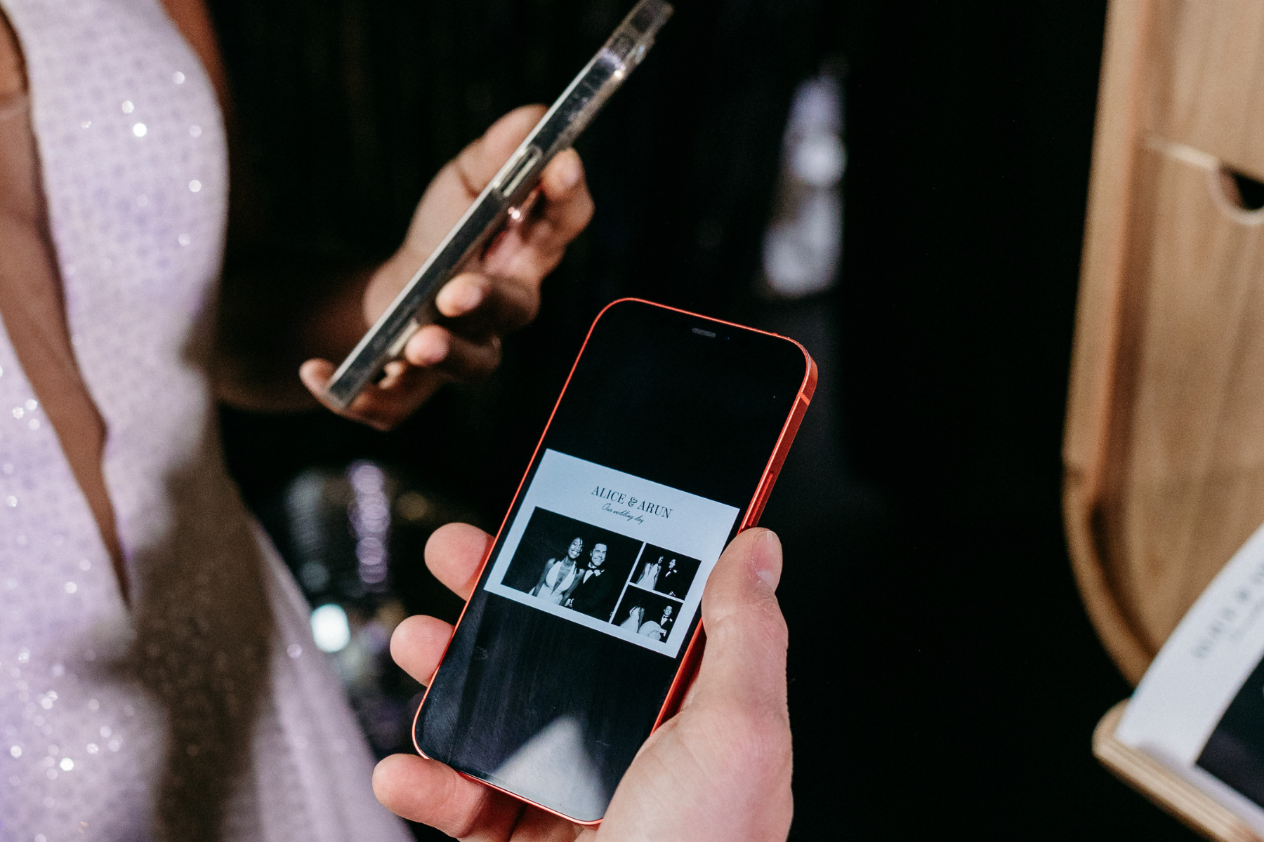 Person holding a smartphone displaying a wedding photo album with the names 'Alice & Arun' and black-and-white photos of a couple.