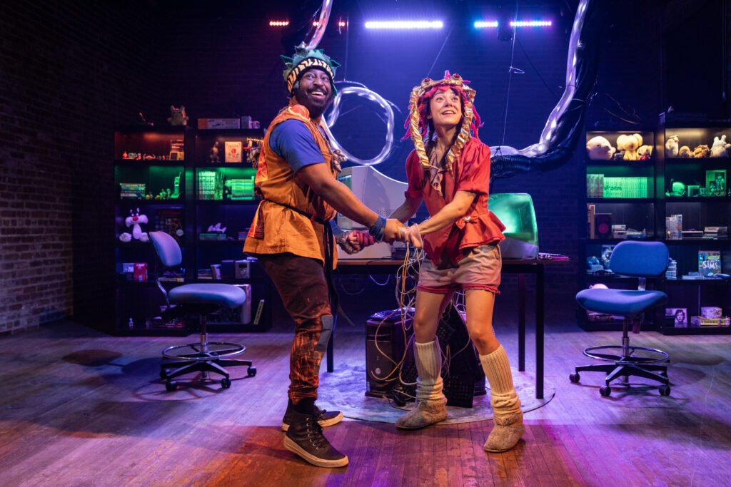 Two people, a man and a woman, dancing and holding hands in a room with colorful lighting, shelves filled with books and objects, and neon signs in the background.