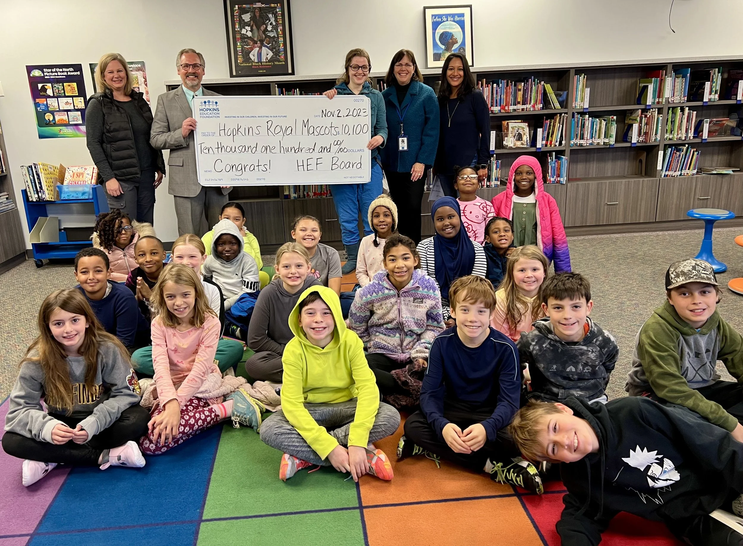Group of students and adults with large grant check