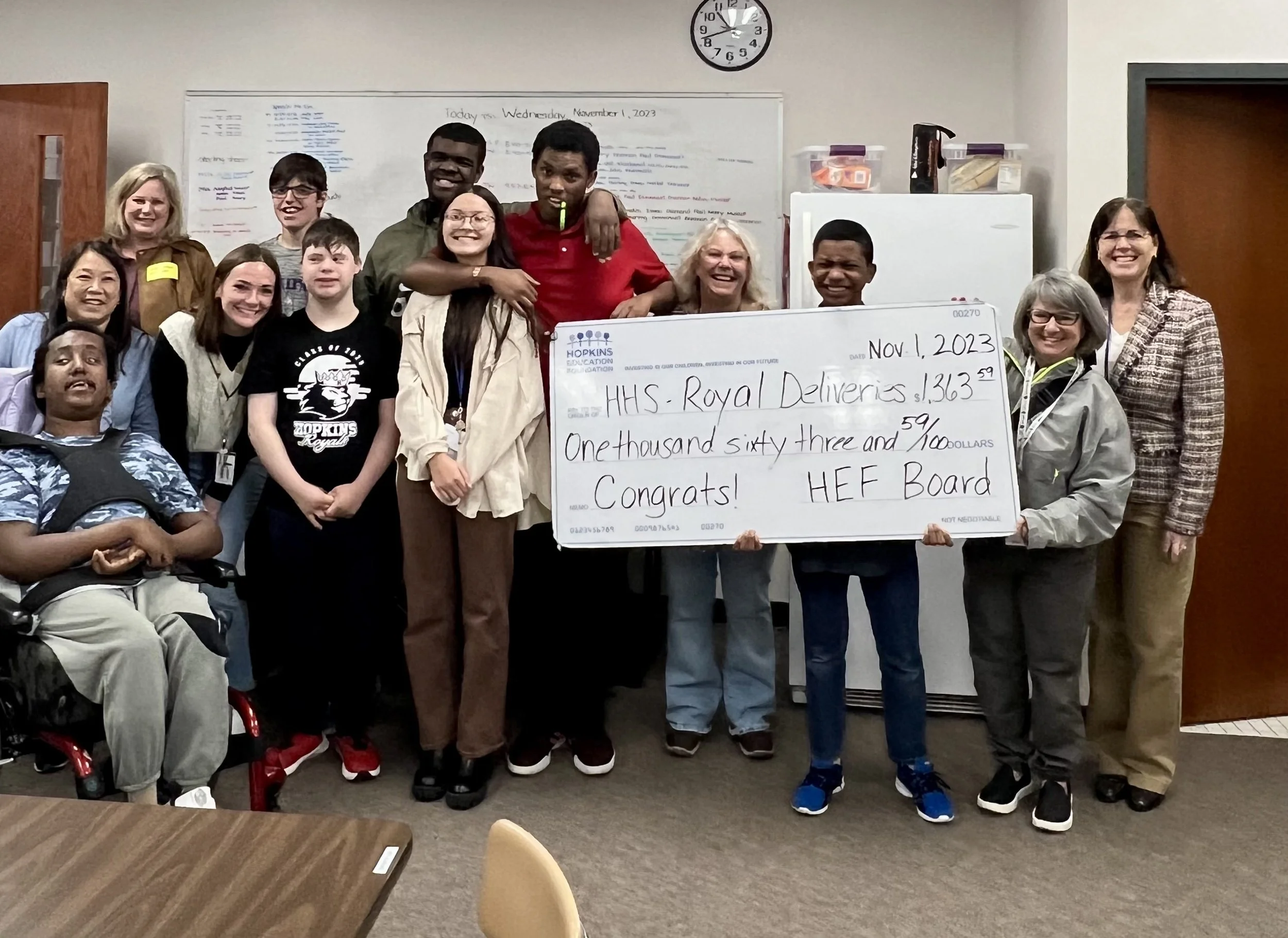 Group of students and adults with large grant check
