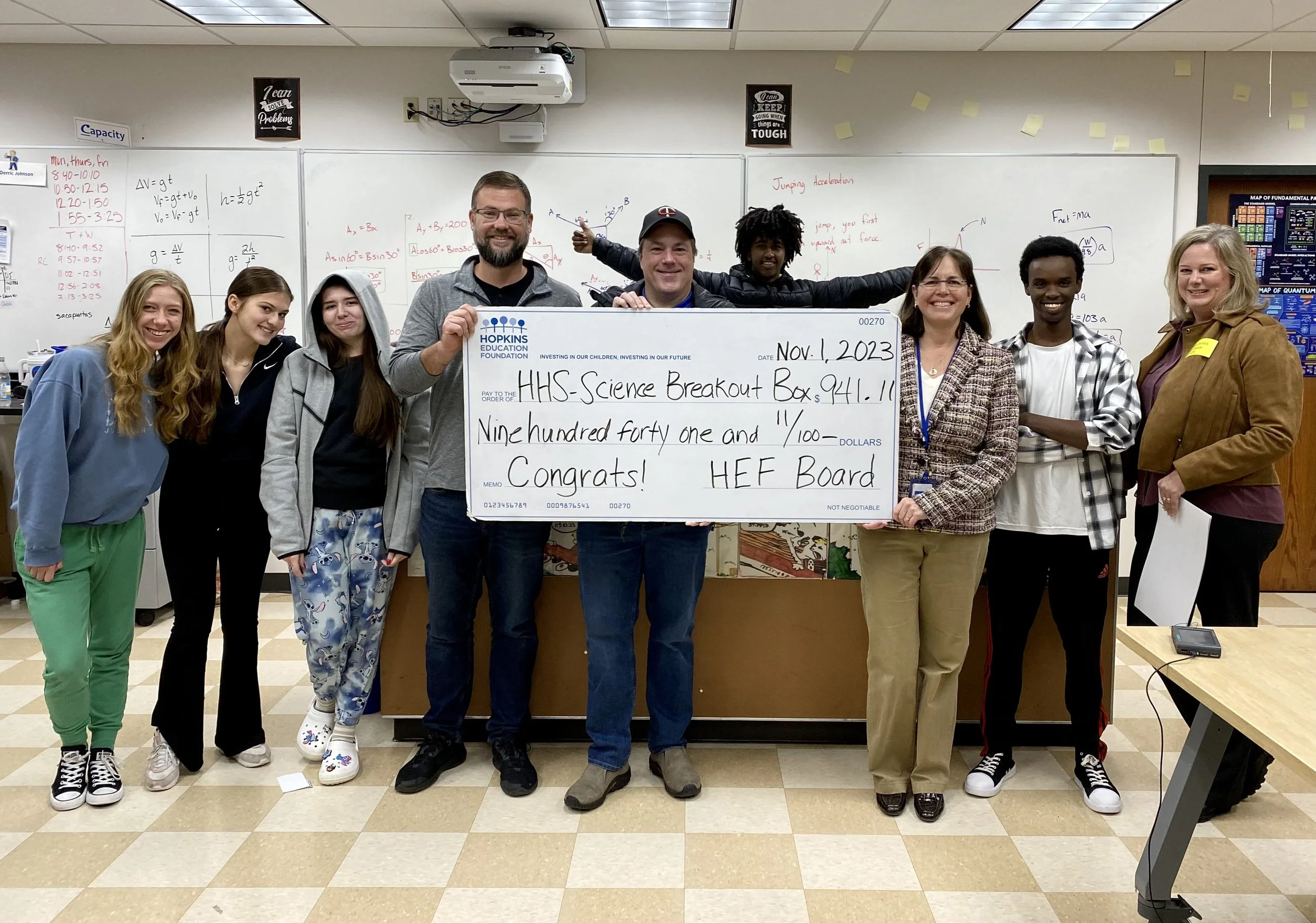 Group of students and adults with large grant check