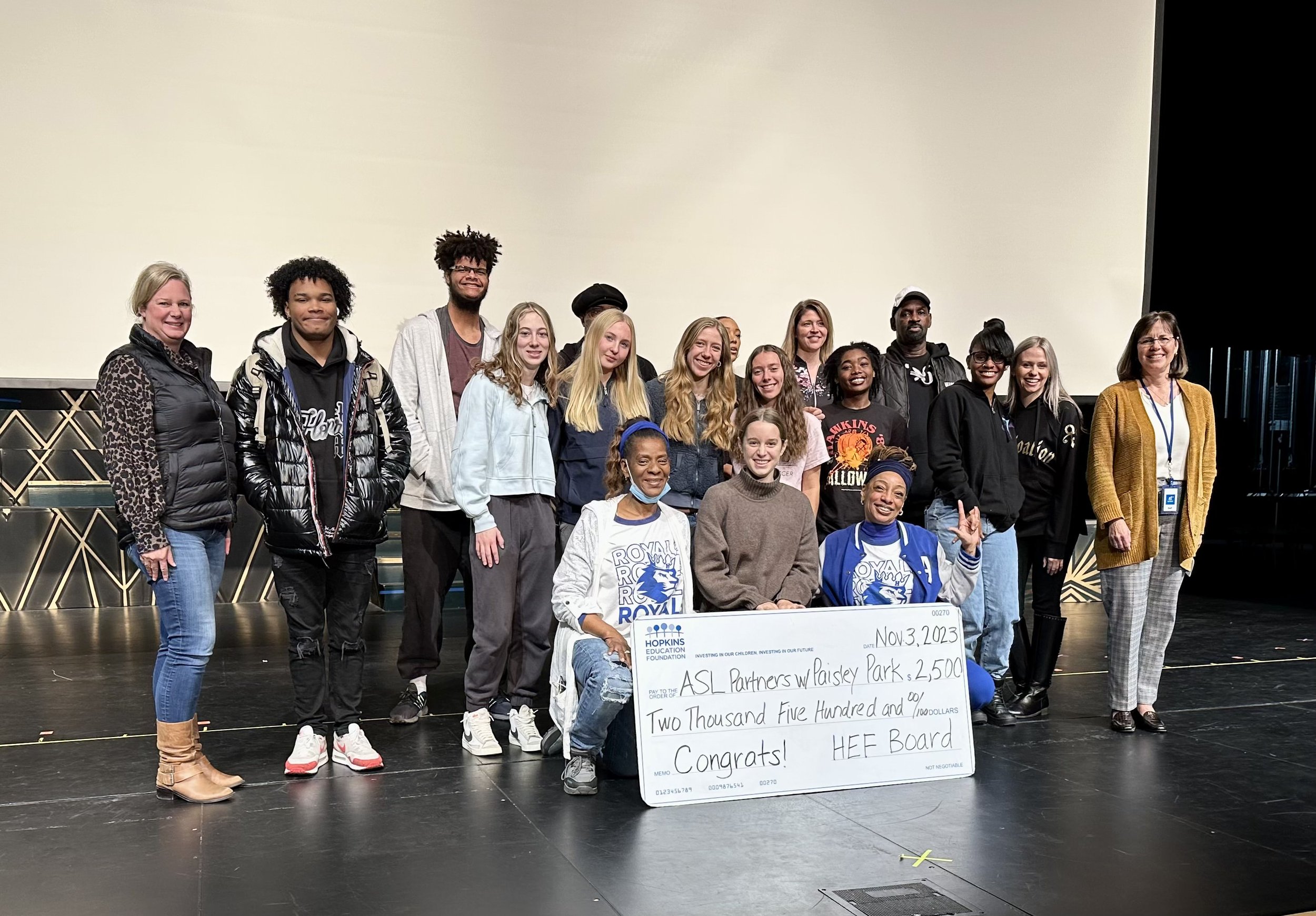 Group of students and adults with large grant check