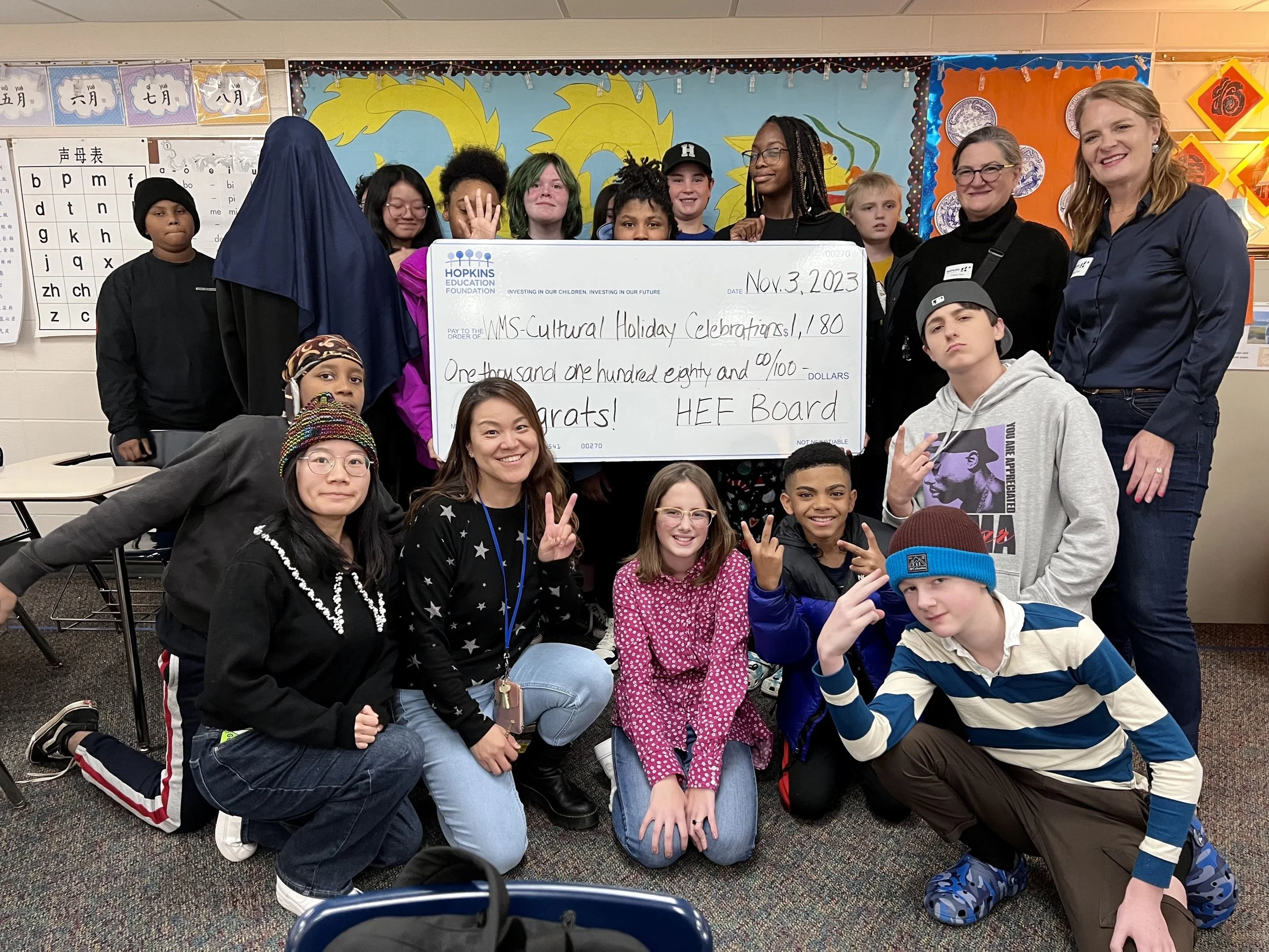 Group of students and adults with large grant check