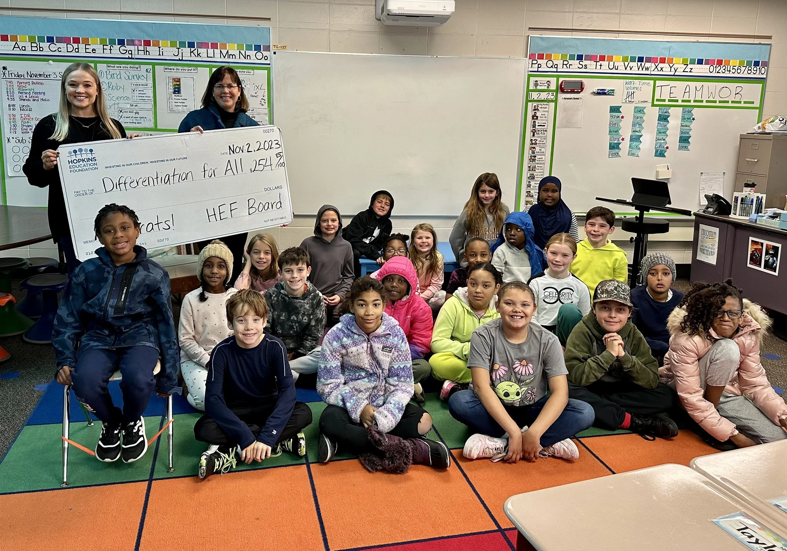 Group of students and adults with large grant check