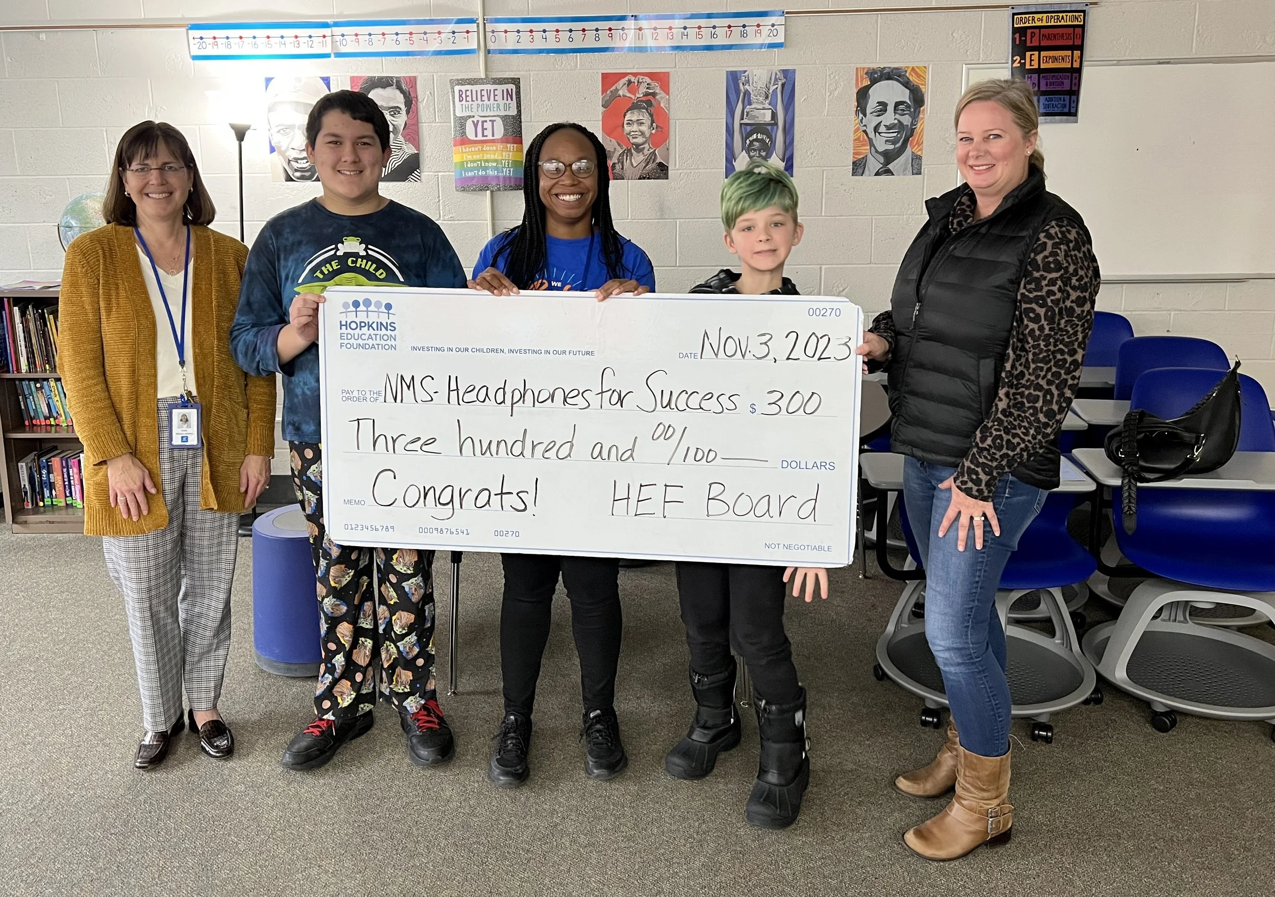 Group of students and adults with large grant check