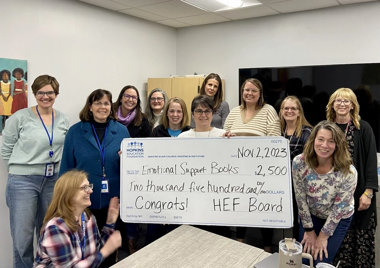 Group of students and adults with large grant check