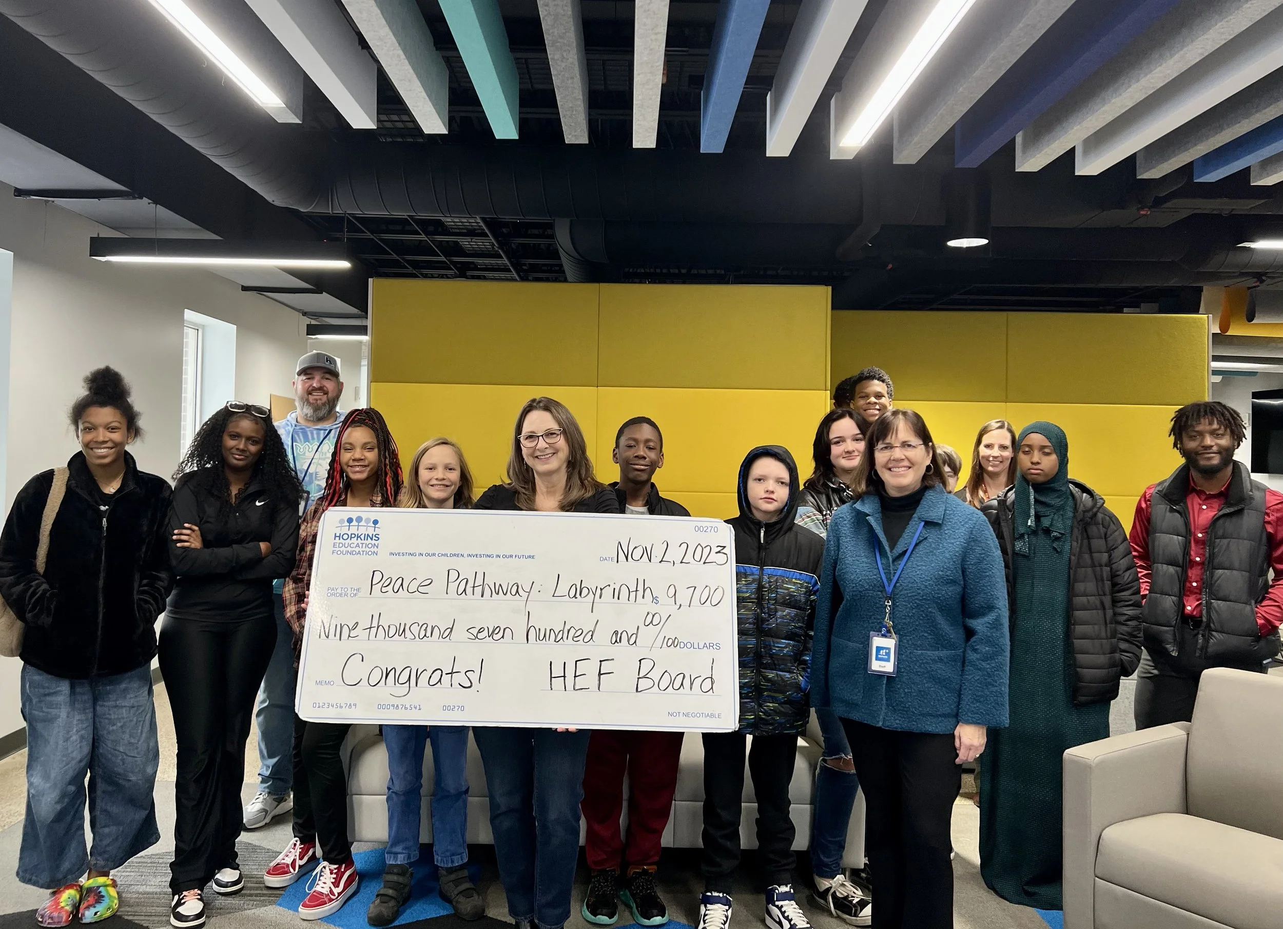 Group of students and adults with large grant check