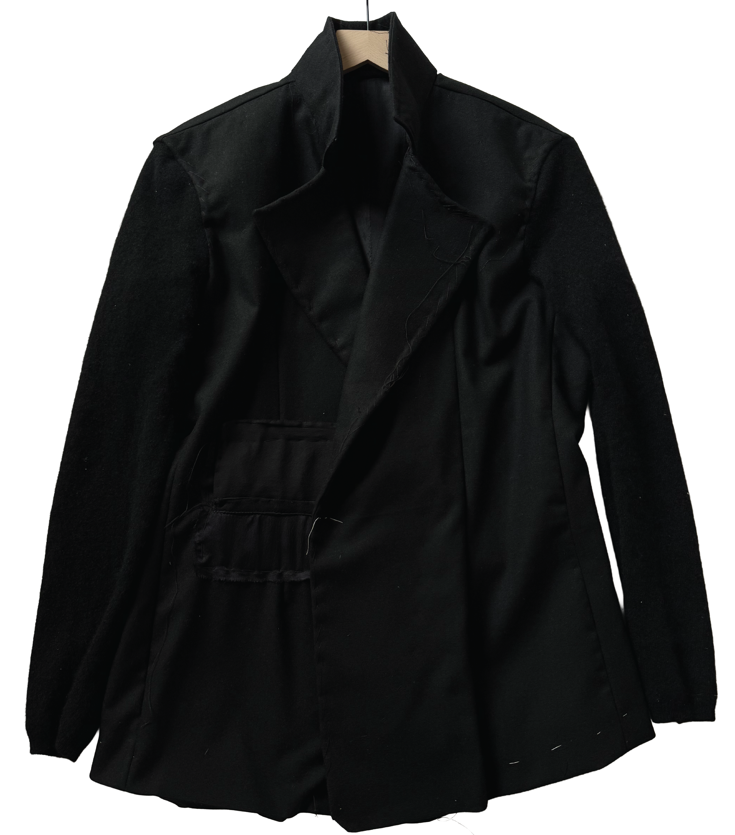 A black coat hanging on a wooden hanger against a white background by conor o'driscoll.