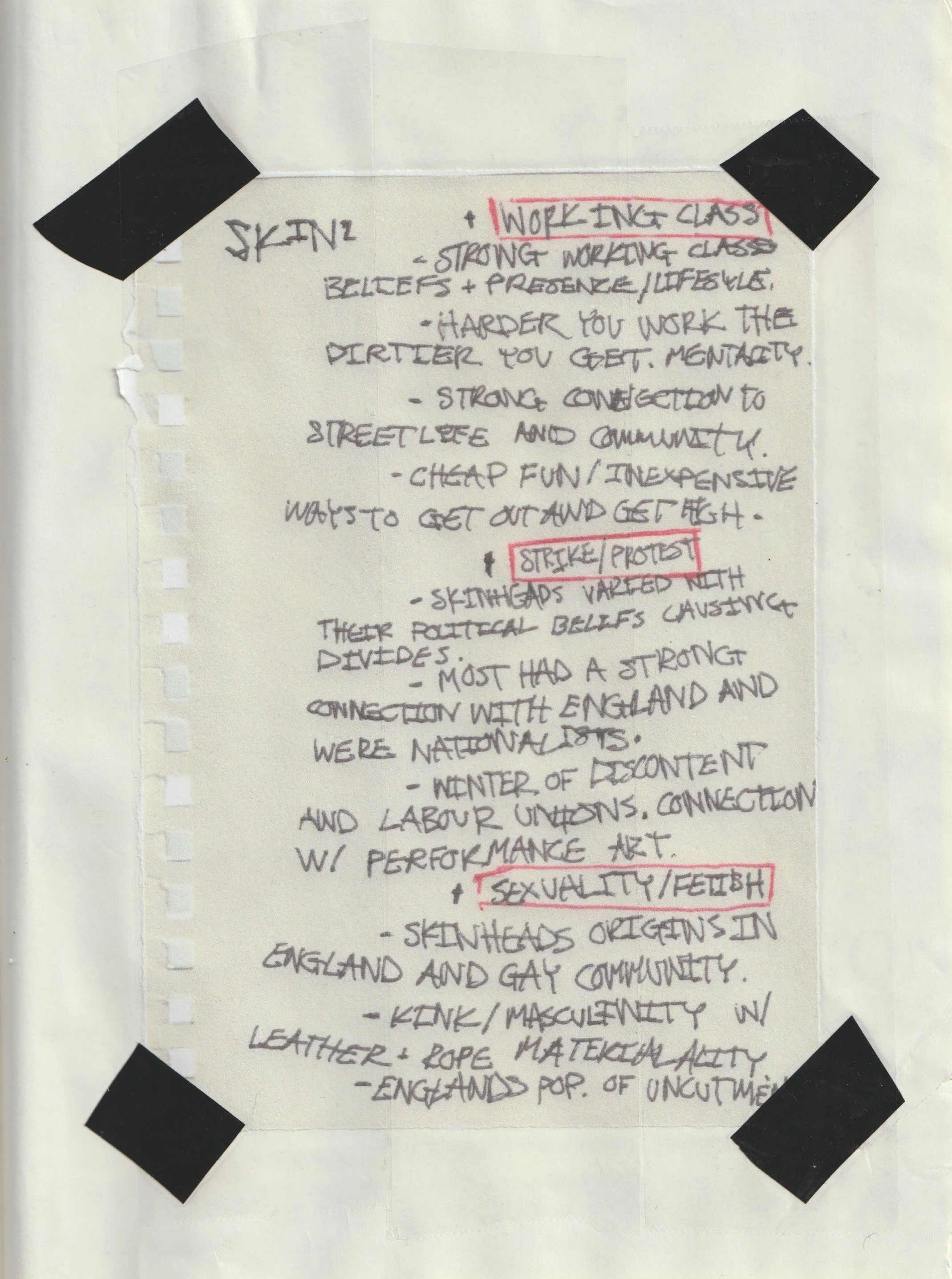 Handwritten notes on a sheet of paper with black tape on each corner. The notes mention topics related to skinheads, work, protest, and sexuality, with some words underlined or highlighted in red, including "WORKING CLASS," "STRIKE/PROTEST," and "SEXUALITY/FETISH."