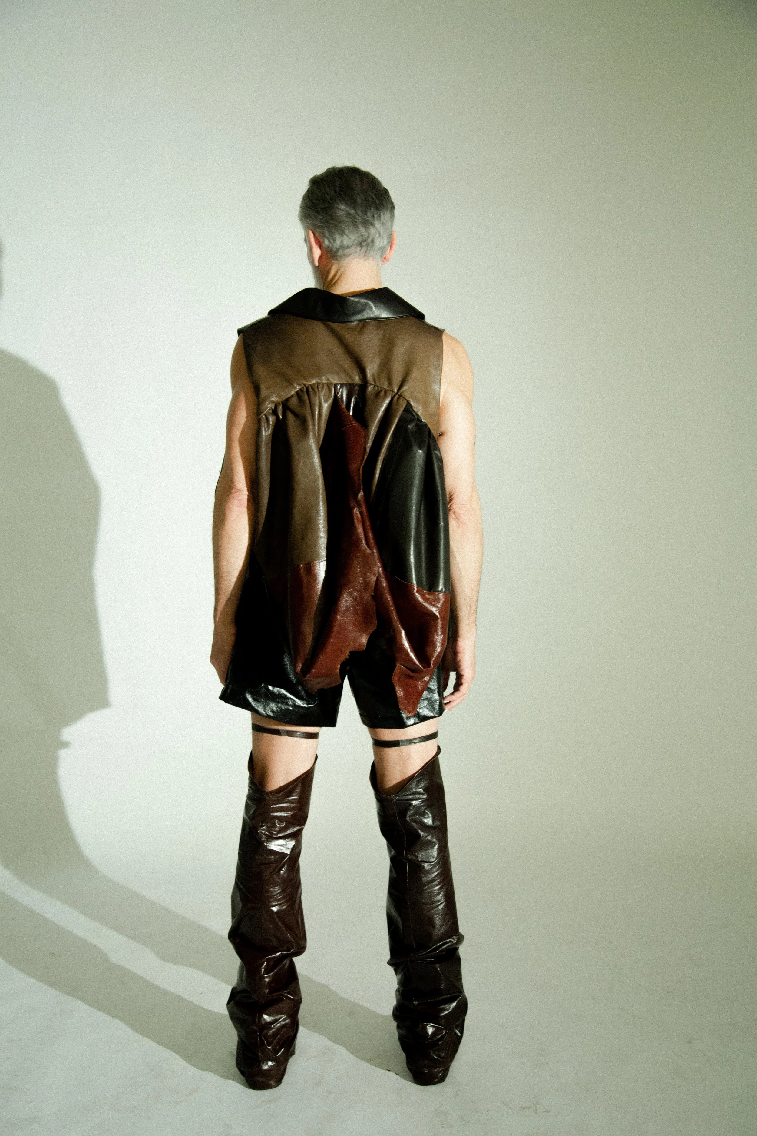 david hand in draped leather jacket, leather boxers, and leather garters by conor odriscoll. sexual narcissism collection, look 2 between the walls. shot by timothy cheng. shoes masion margiela