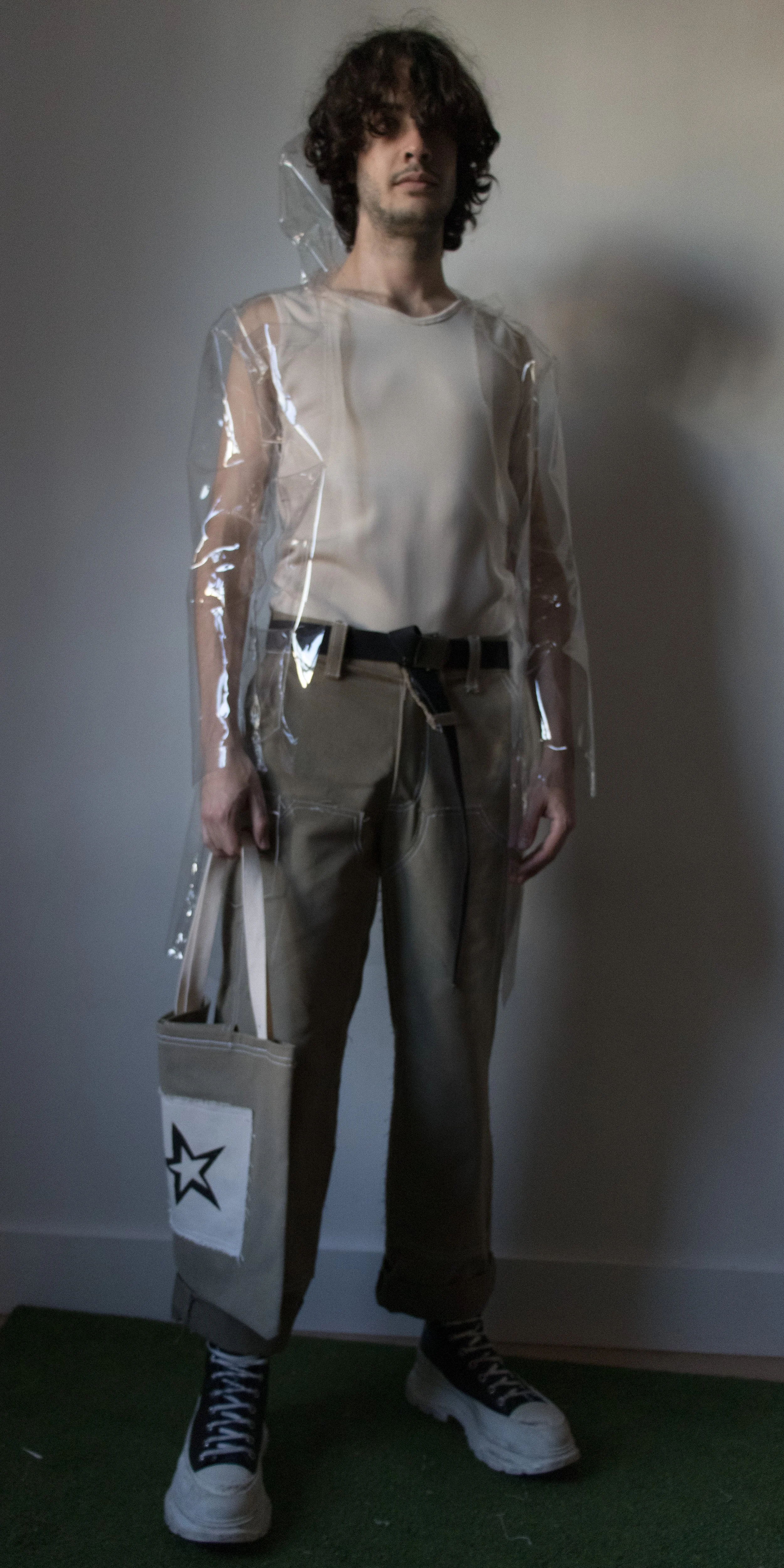 darcy wearing clear star raincoat office tank top and green belt workpants and star tote bag  by conor odriscoll for defective workwear collection conor o'driscoll new york city nyc