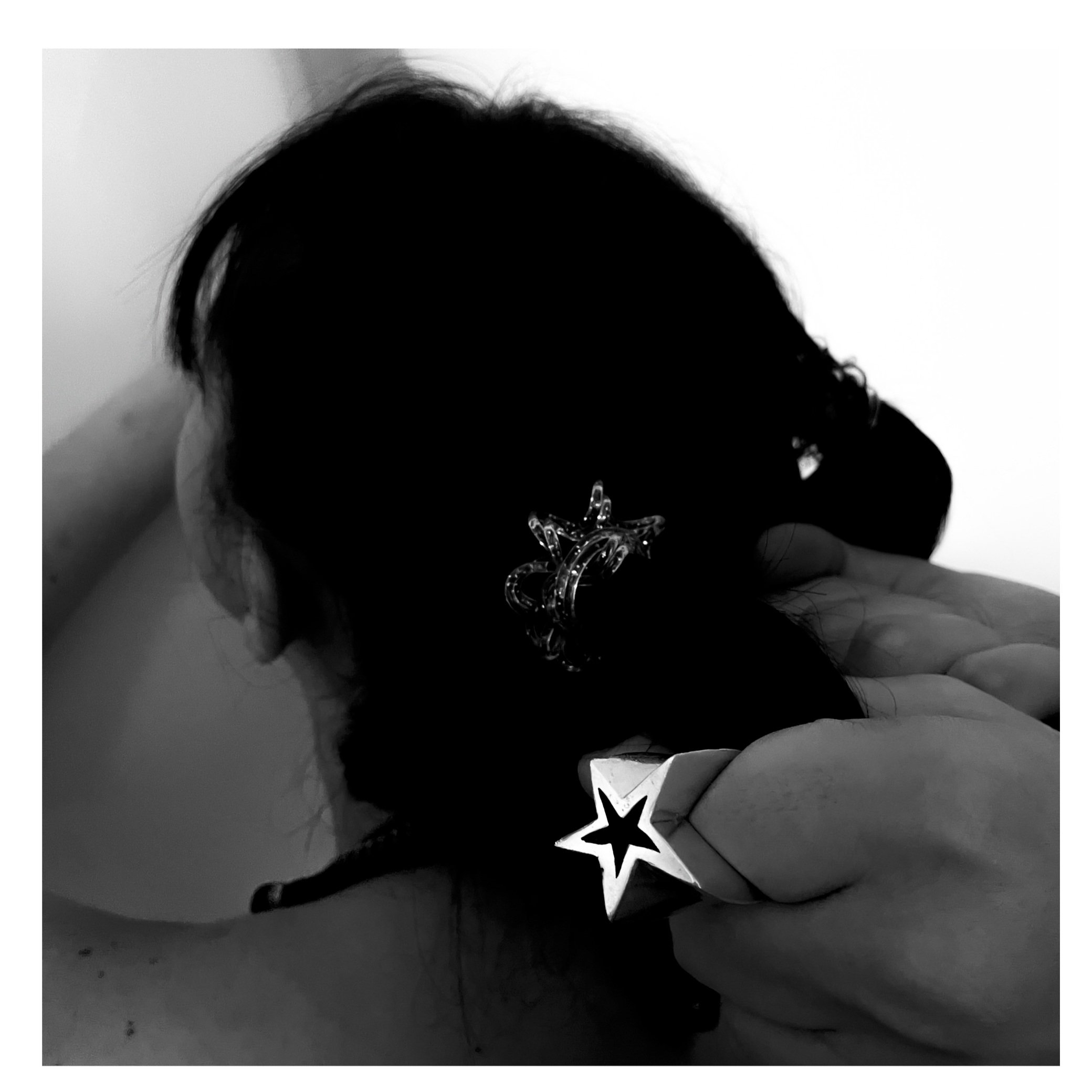 fetish star ring photography chunky silver star ring hair pulled back against wall black and white film photography editorial jewelry.