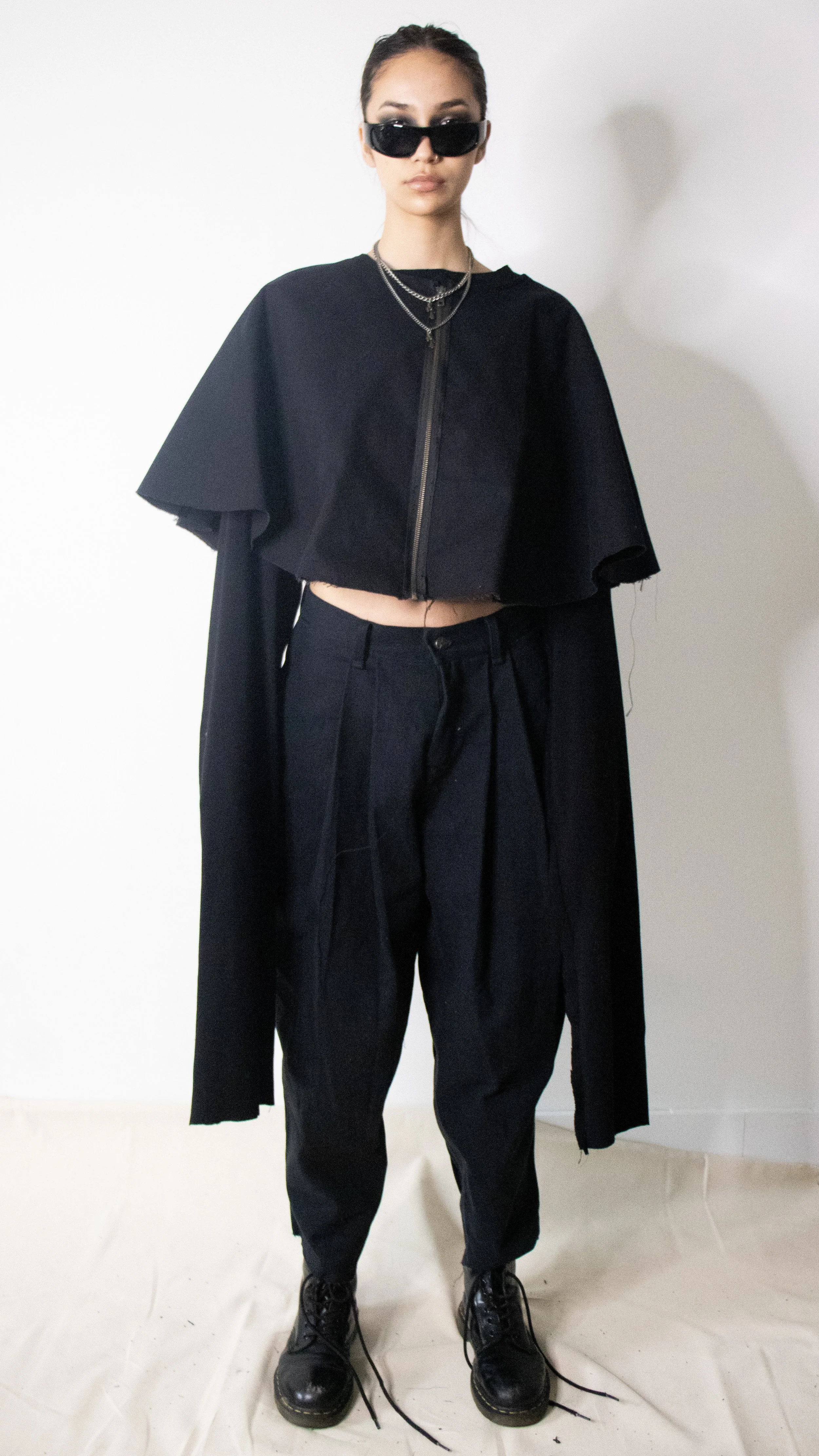 sharon bruck wearing canvas cape pleated pants and oversized cropped top by conor odriscoll cult collection