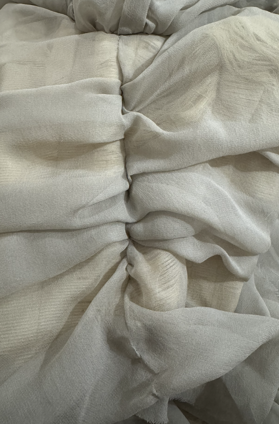 CONOR ODRISCOLL FOR VETTESE. S26 NYFW Close-up of a beige, textured fabric with gathered, ruched sections.