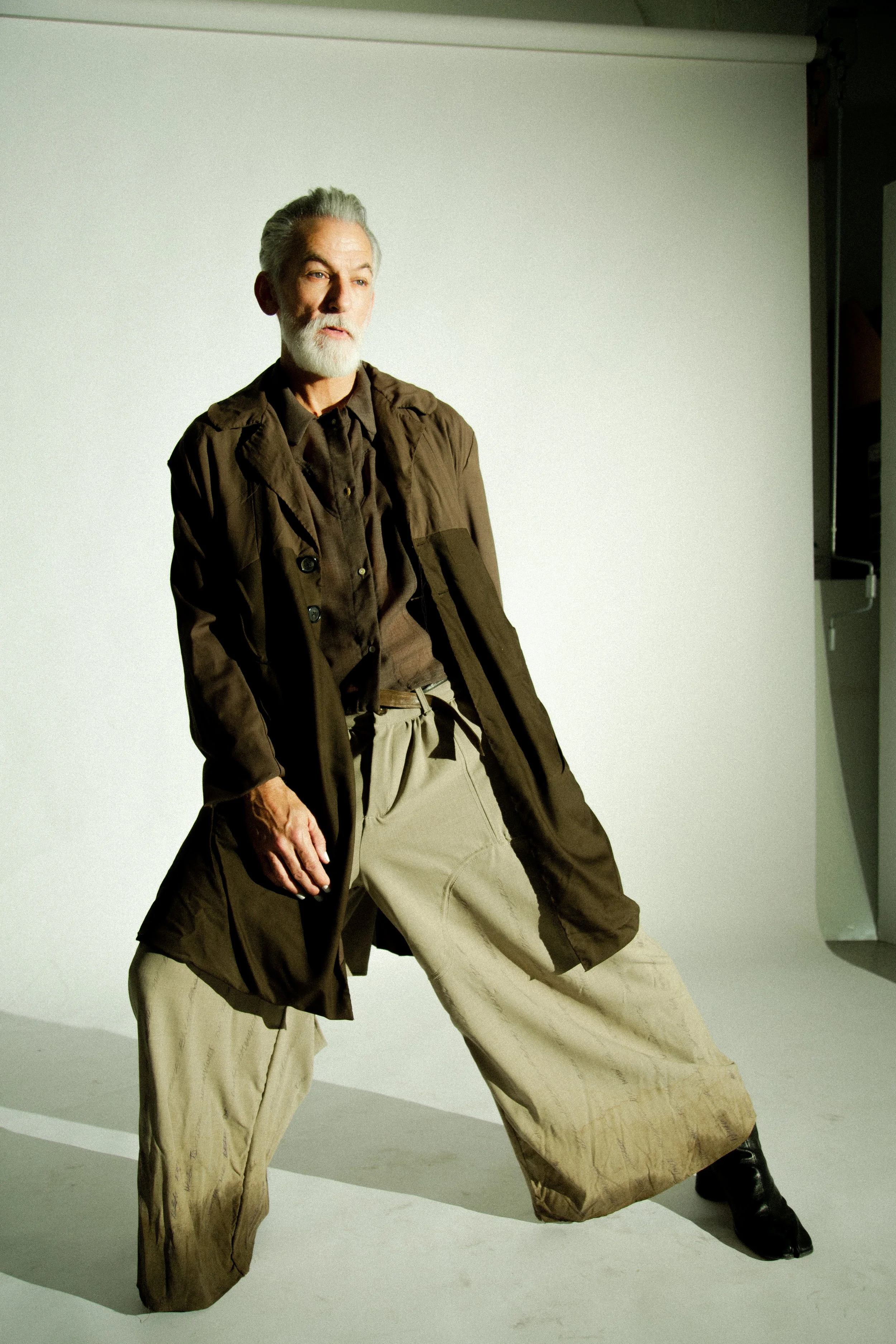 david hand in wrinkled wool two tone dirt coat, sleeveless wool dress shirt and wool dirt dipped love pants from sexual narcissist collection. look one waiting for my lover by conor odriscoll. shot by timothy cheng. new york city.