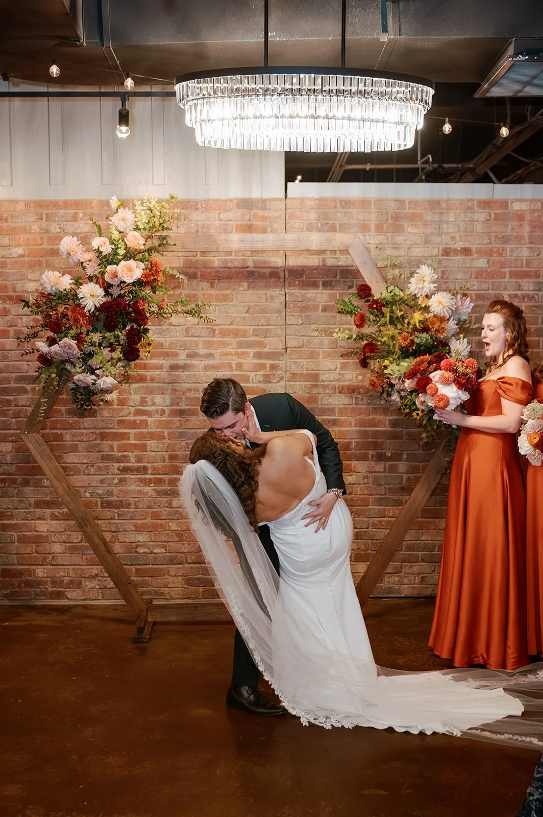 bride groom kiss flower floral arrangement wedding arch autumn main street ballroom ellicott city maryland