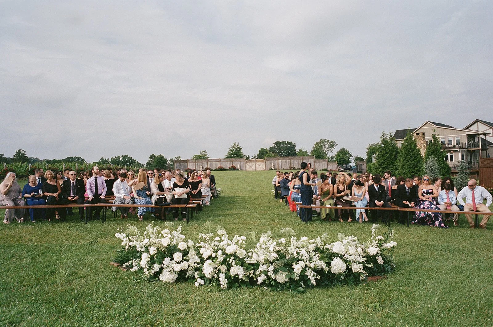 WEDDING CEREMONY WHITE FLORAL GROUND ARCH FIELD STONE TOWER WINERY VIRGINIA