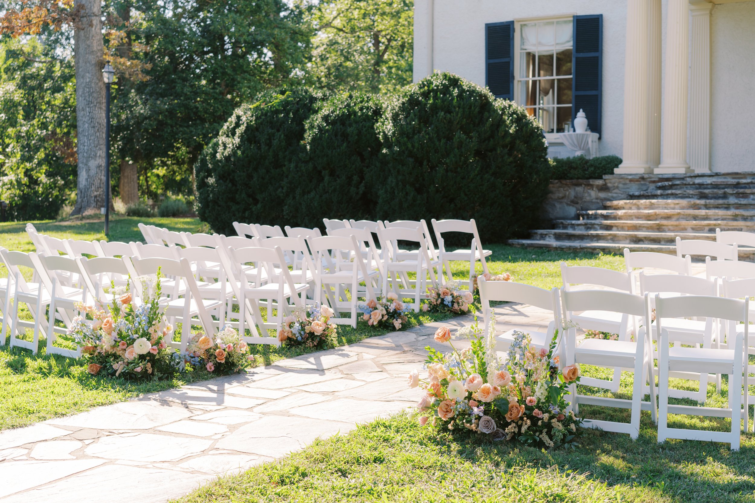 WEDDING CEREMONY OUTDOOR GARDEN COLORFUL FLORAL GROUND ARRANGEMENTS CENTERPIECE RUST MANOR HOUSE
