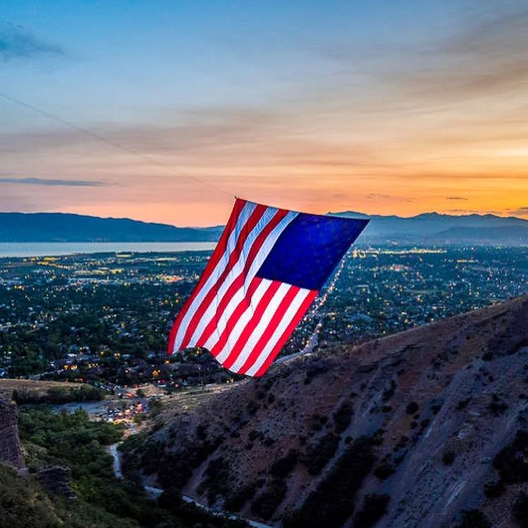 The Major flag overlooking Coldwater Canyon in North Ogden Utah, with surrounding residential and commercial areas served by asphalt paving, repair, and maintenance services.