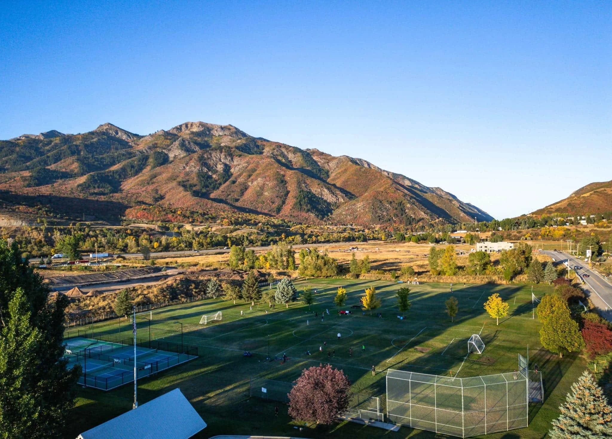Aerial view of Morgan Utah mountain‑valley neighborhoods, HOA communities, and commercial areas needing asphalt paving, sealcoating, crack sealing, and long‑term pavement maintenance services