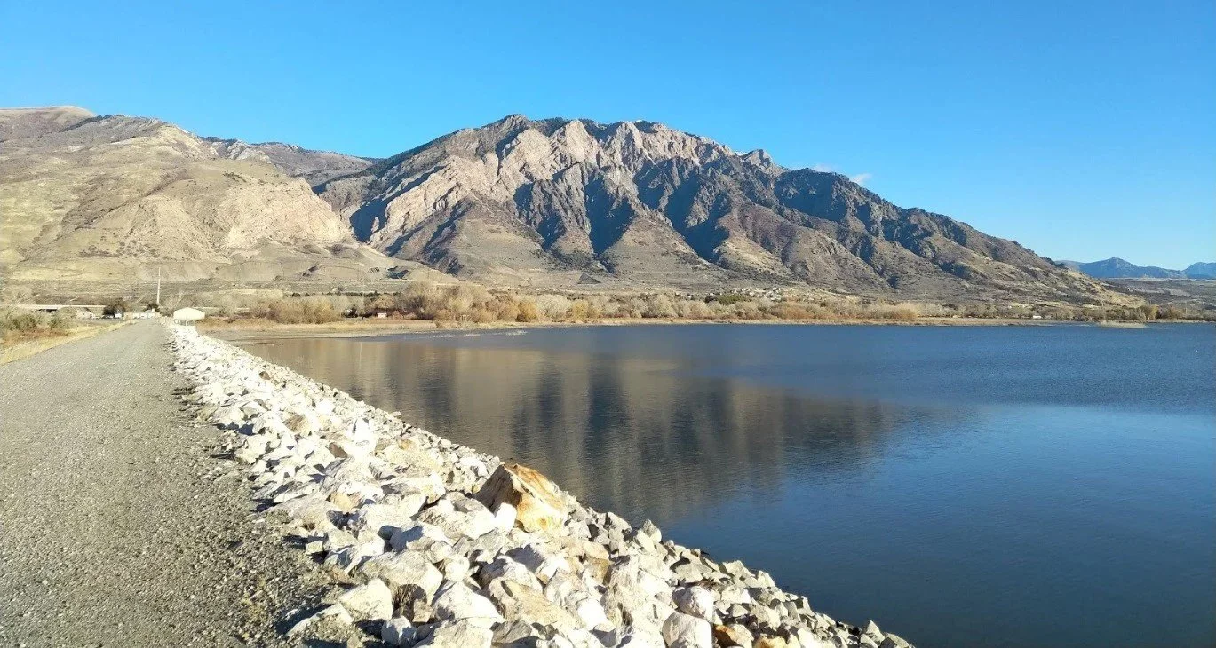 Willard Bay service road causeway in Willard Utah looking toward Willard Peak, near residential and commercial areas served by asphalt paving, repair, and maintenance services.