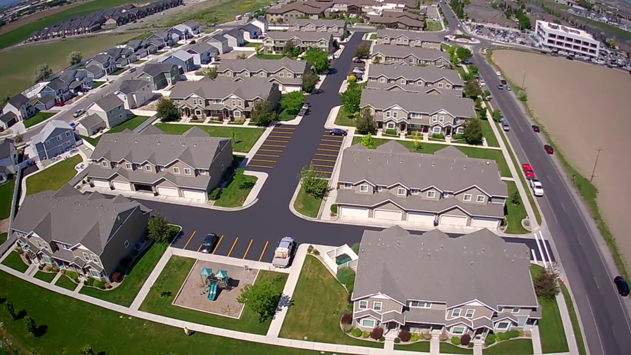 Aerial view of townhome parking lot crack sealing, sealcoating, and restriping project in Logan, Cache County, Utah.