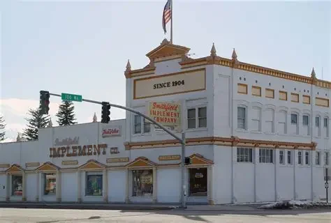 Historic Smithfield Implement building on 100 North in Smithfield Utah with an American flag, near residential and commercial areas served by asphalt paving, repair, and maintenance services.