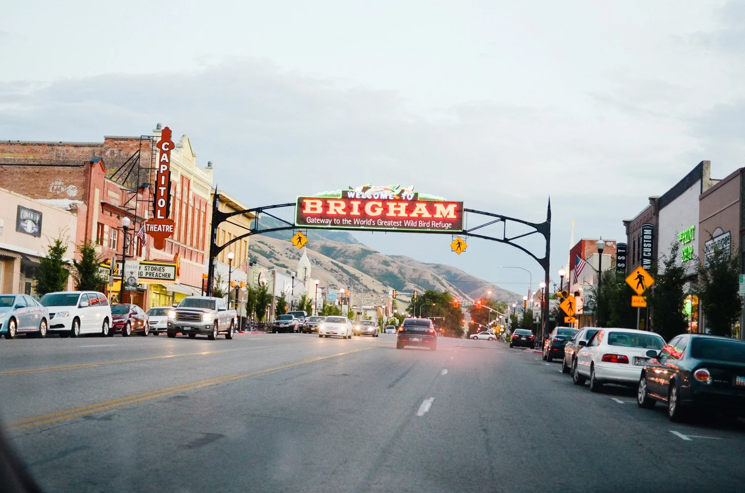 Downtown Brigham City Utah Main Street with the ‘Gateway to the World’s Greatest Wild Bird Refuge’ sign, near residential and commercial areas served by asphalt paving, repair, and maintenance services.