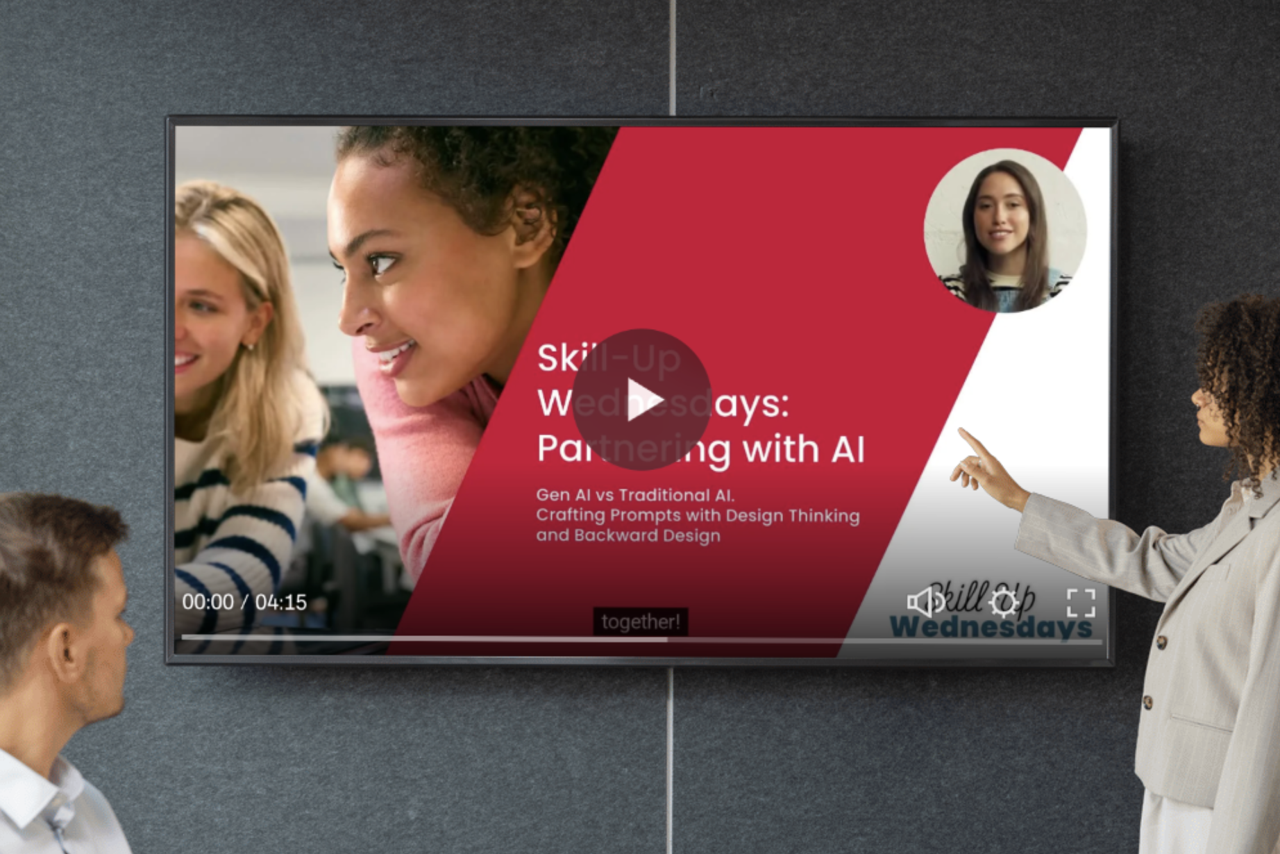 A classroom or conference room with a large screen displaying an educational video titled 'Skill-Up Wednesdays: Partnering with AI.' The slide shows a woman pointing towards the screen with a diverse group of students or participants engaged and smiling. The video controls indicate it is 4 minutes and 15 seconds long, with options for volume and full-screen mode.