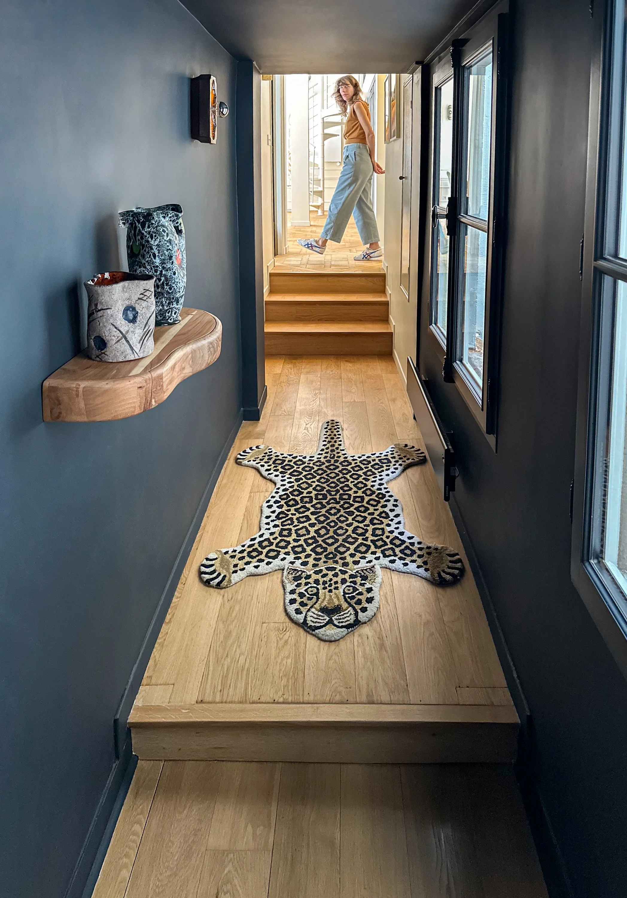 Peint dans un bleu profond, presque noir, le couloir d’entrée accentue la découverte du séjour lumineux et de sa double hauteur.