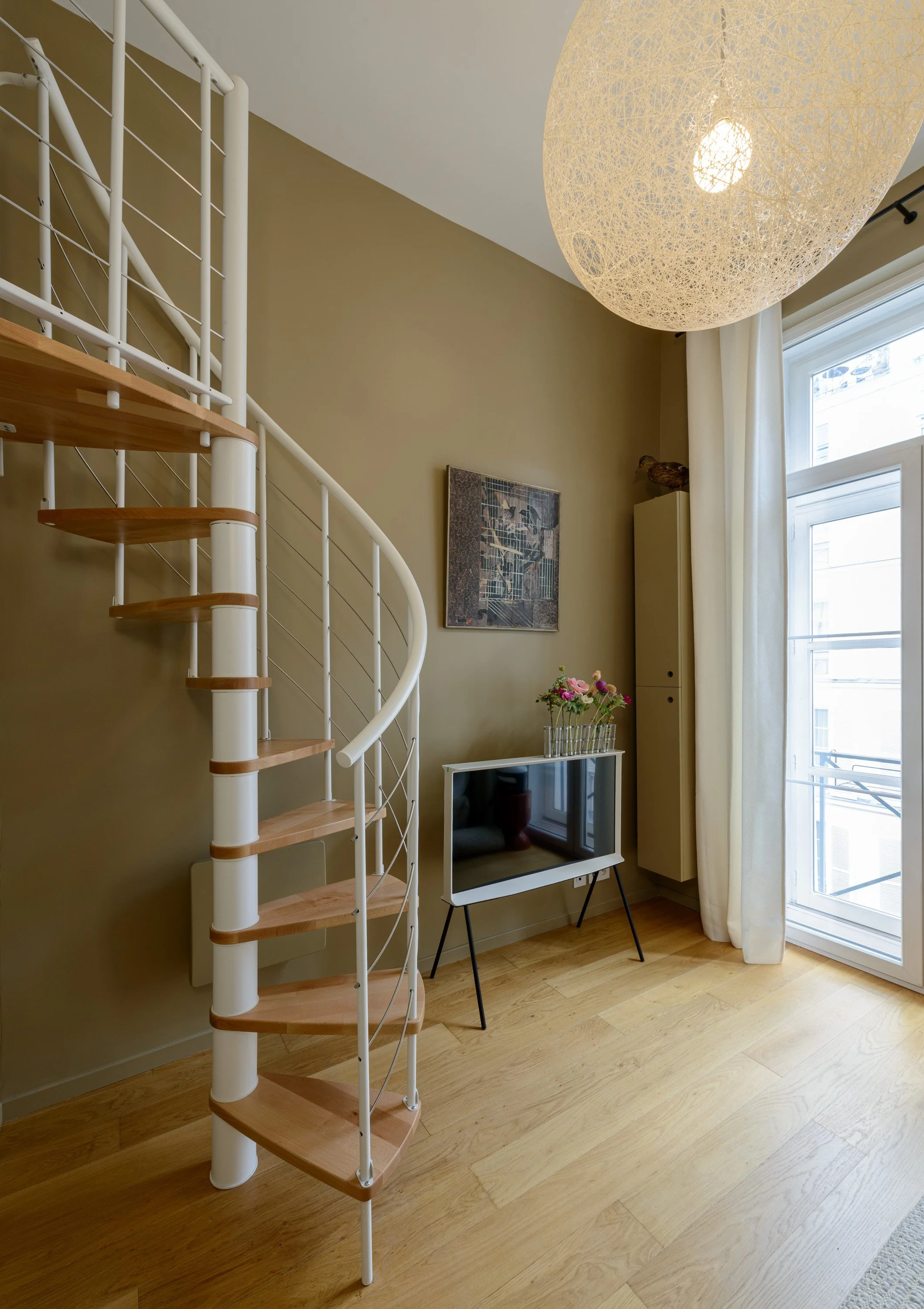 Les murs et les rangements sur mesure sont peints dans une même teinte, "Falaise" de chez Ressource, pour envelopper le bureau. Le nouvel escalier facilite l’accès au dressing.