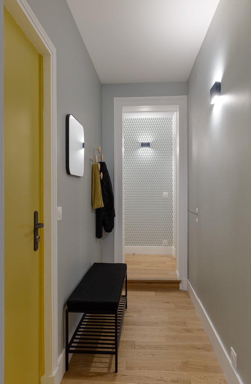 La porte d’entrée jaune transforme l’entrée en un espace lumineux et plein de caractère.

Applique : Lumicon
Banc : Westwing
Miroir : La fabrique des Styles