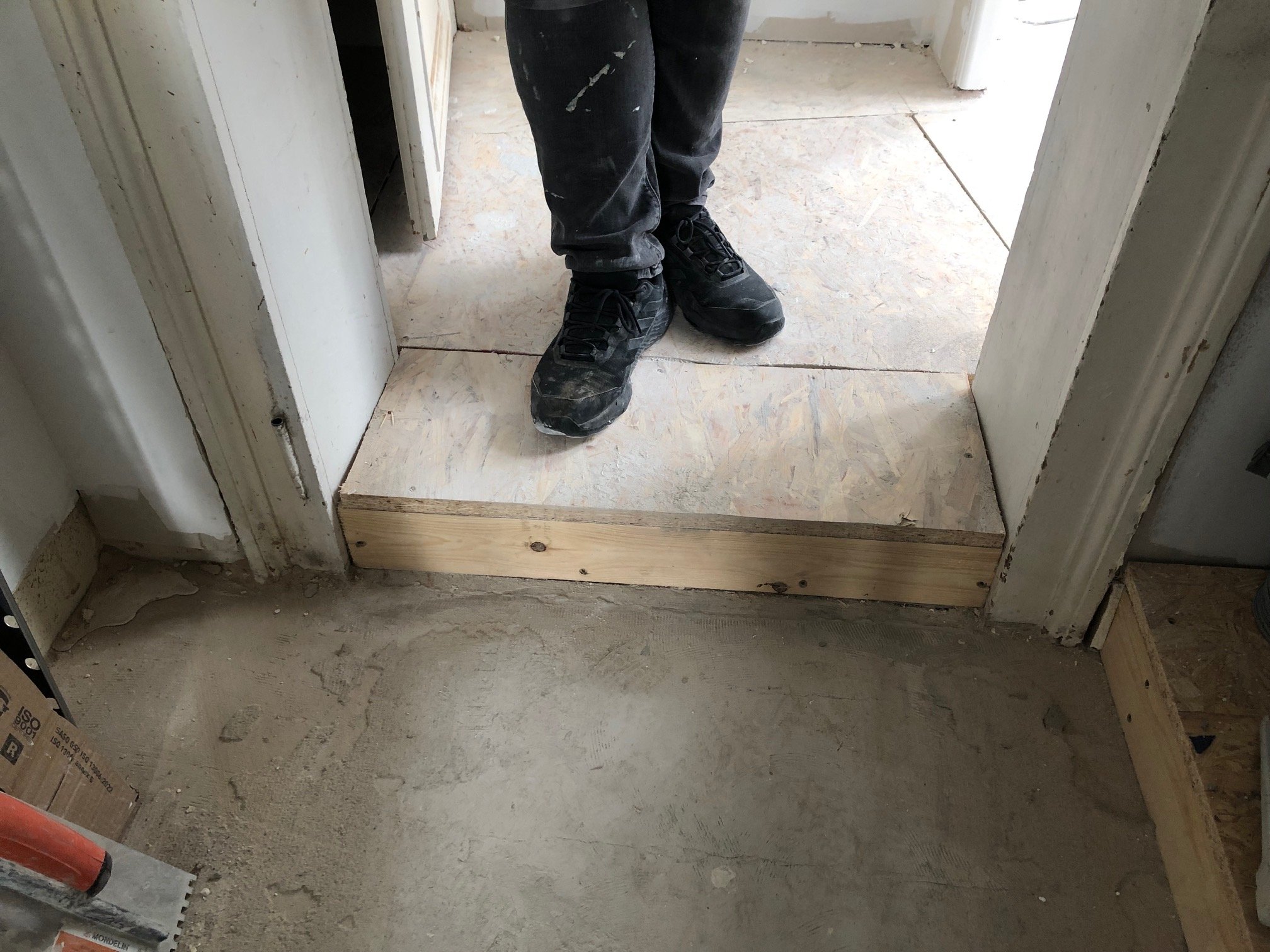 La marche dissimule les réseaux d'eau de la cuisine et de la mini-buanderie.