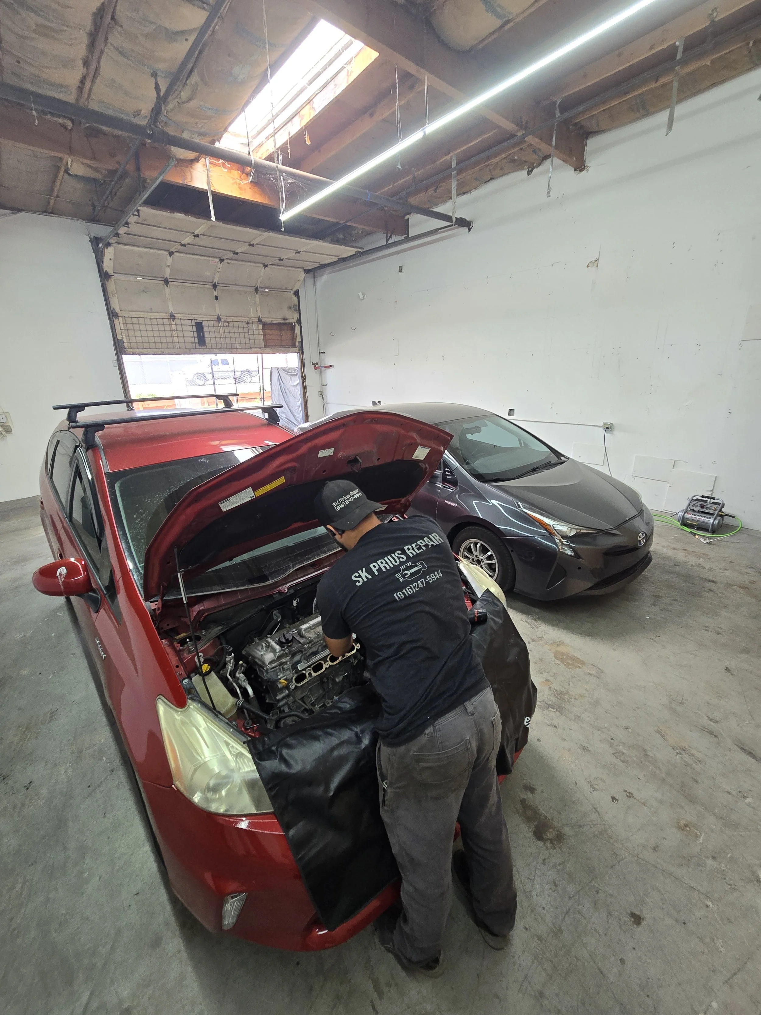 red prius with mechanic inside shop.jpg