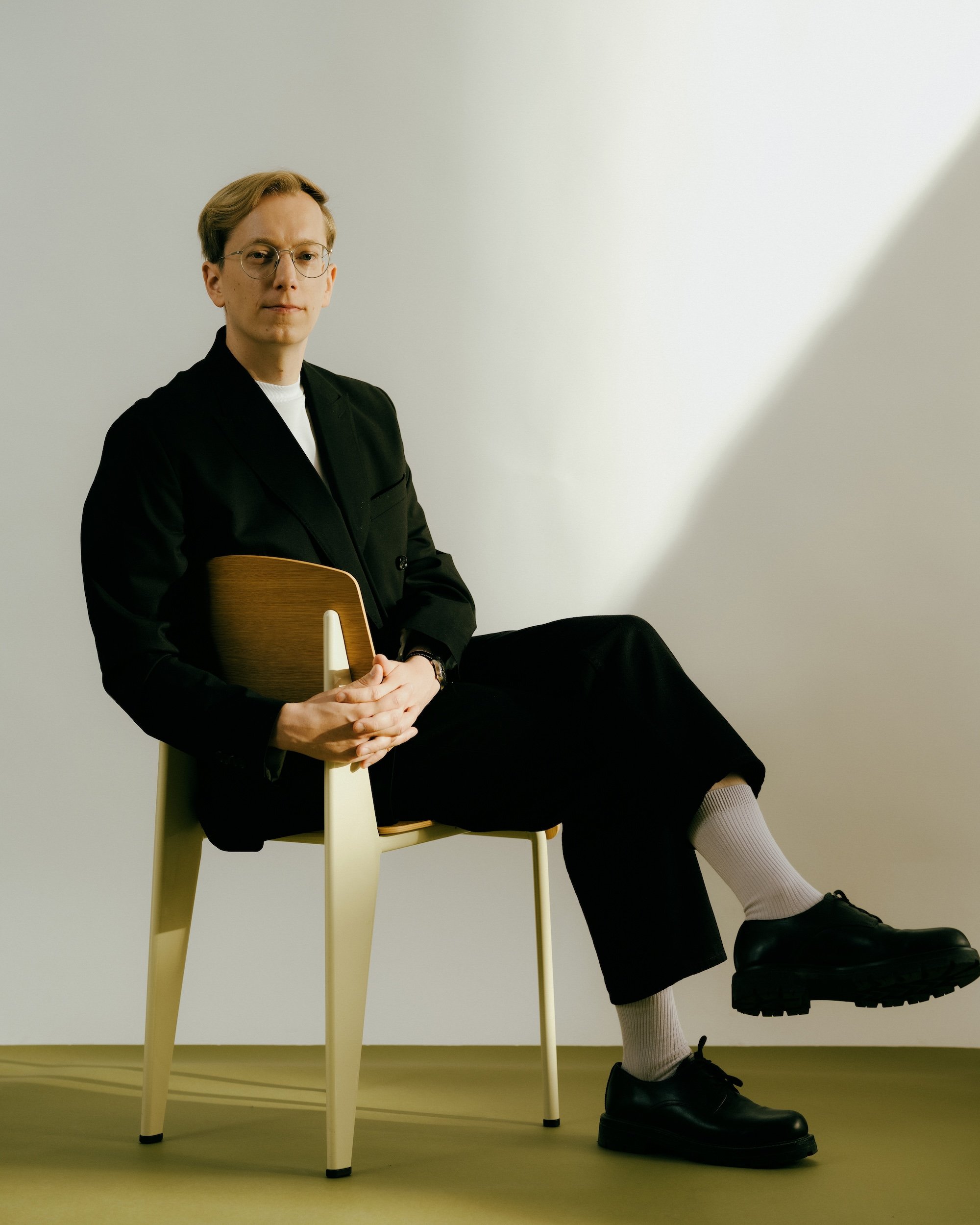 Matti Lehto istuu valkoisella tuolilla, jolla hän pitää kitaraa sylissään, pukeutuneena mustaan takkiin, valkoiseen paitaan, mustiin housuihin ja mustiin nilkkasaappaisiin. Hän katsoo suoraan kameraan ja on taustalla valkoinen seinä.