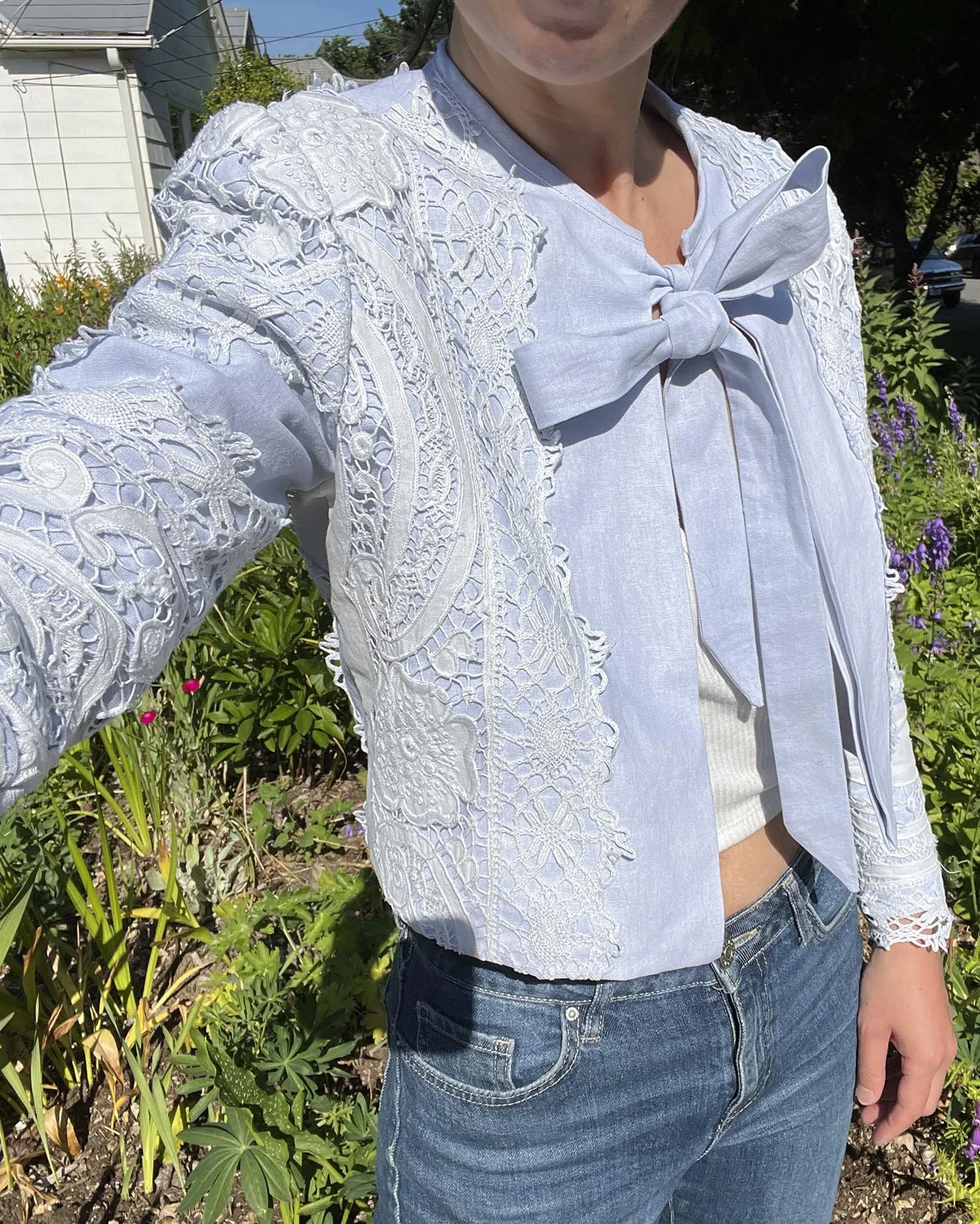 Pale blue cropped jacket made from linen and antique lace, with tie at front neckline