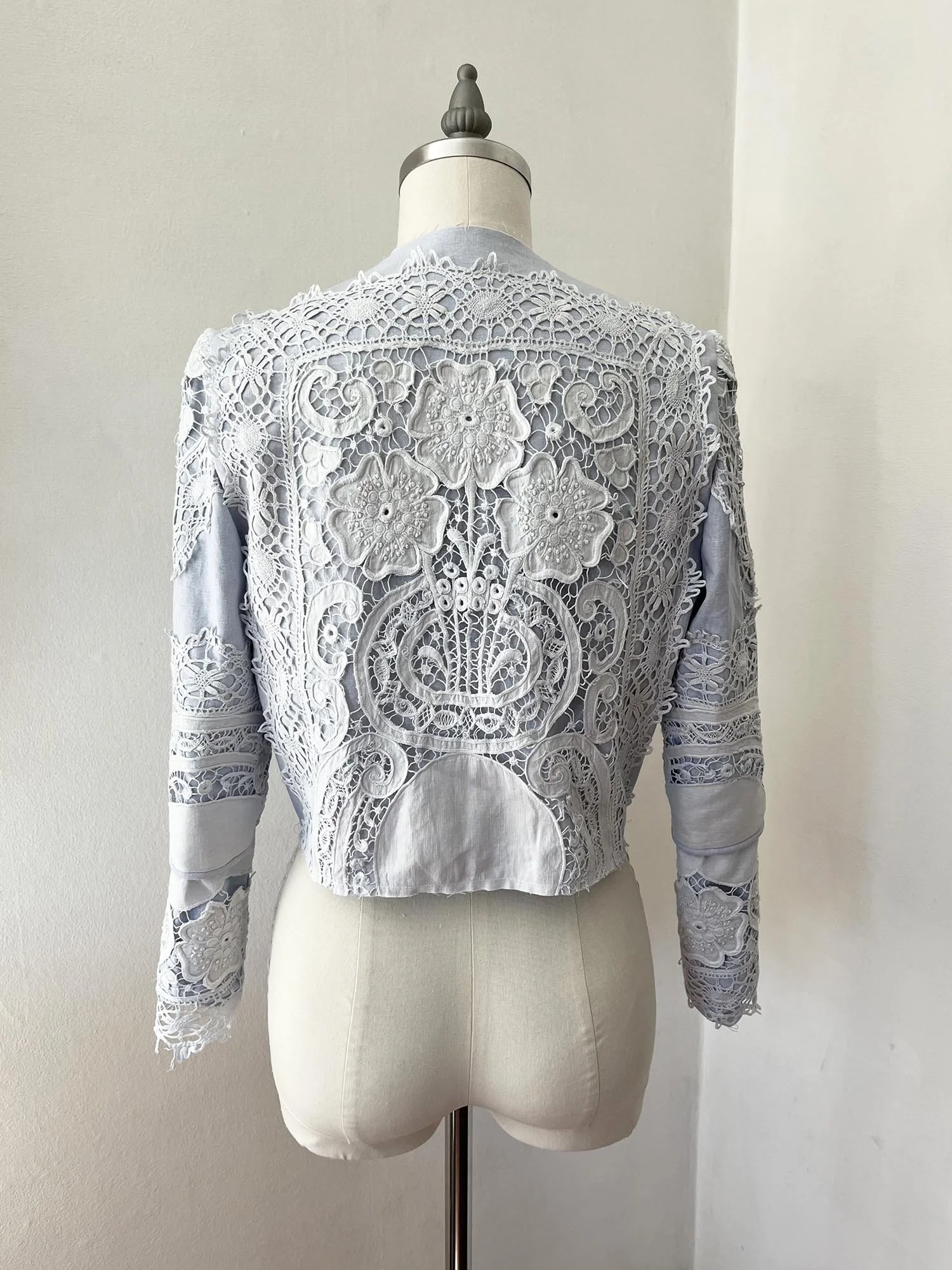 Pale blue cropped jacket made from linen and antique lace, with tie at front neckline