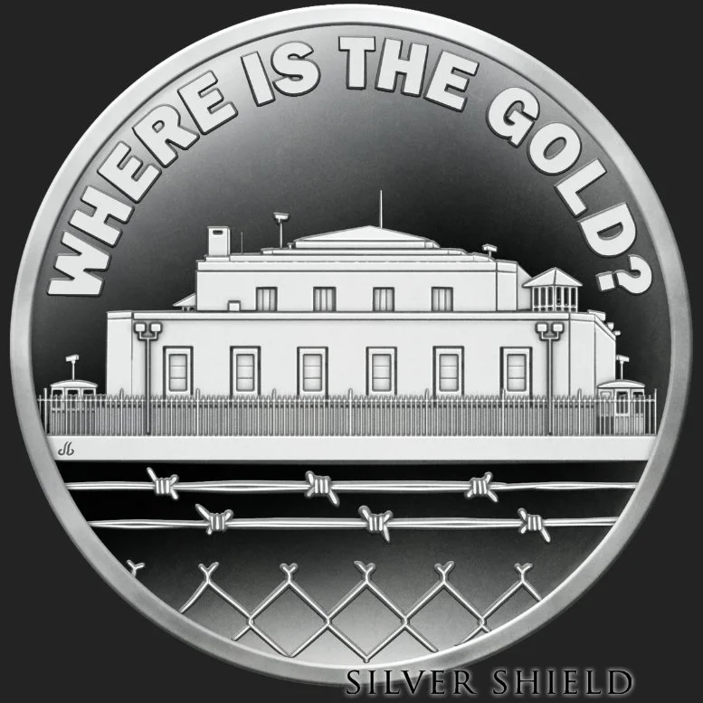 A silver coin with the phrase "Where Is The Gold?" at the top and the name "Silver Shield" at the bottom. The coin features an illustration of a building with a fence, barbed wire, and guard towers.