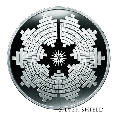 A minted silver proof coin with intricate geometric patterns and the text "Silver Shield" at the bottom.