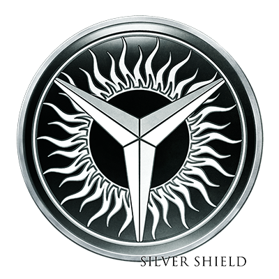 A minted silver proof coin with stylized flames around the inner circle and a three-pointed star in the center, labeled 'Silver Shield' at the bottom.