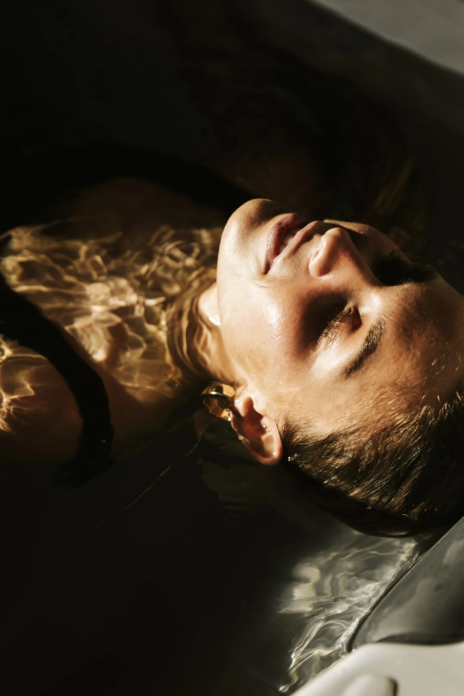 Client relaxing in the cold plunge contrast therapy room, representing self-care and rejuvenation.