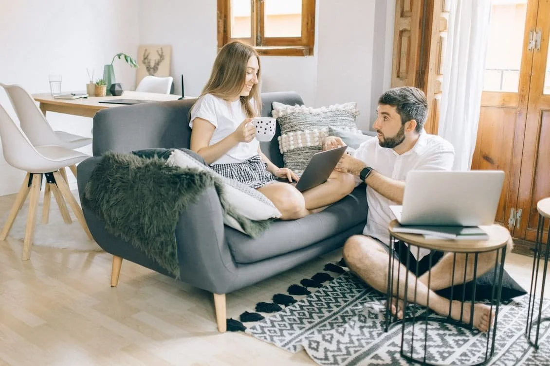 man-and-woman-talking-while-working-at-the-living-room