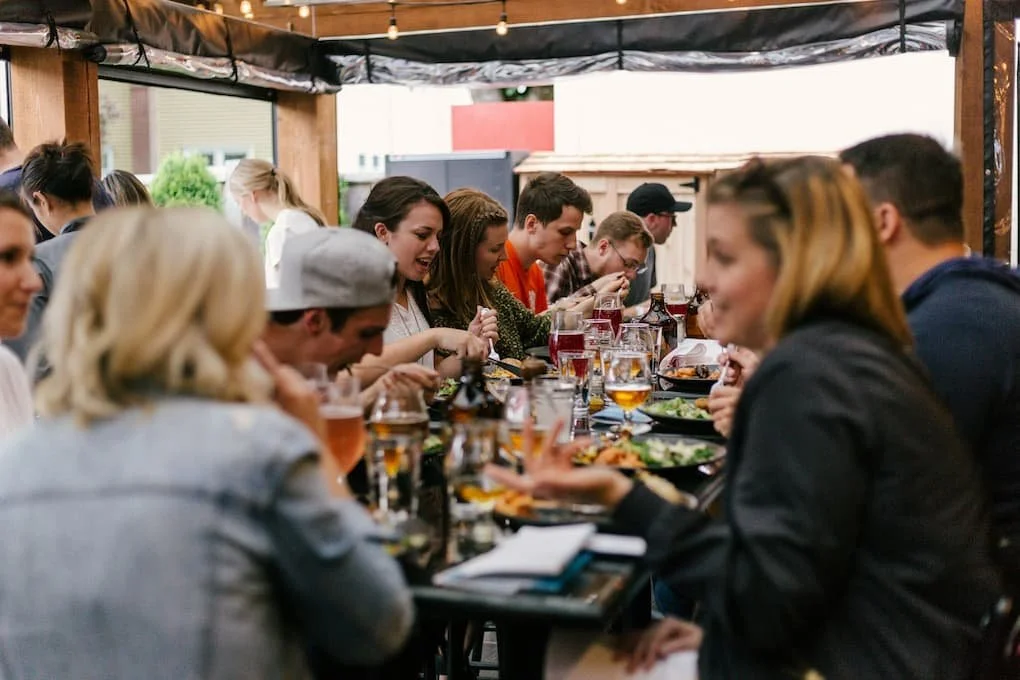people-sitting-in-front-of-table-talking-and-eating