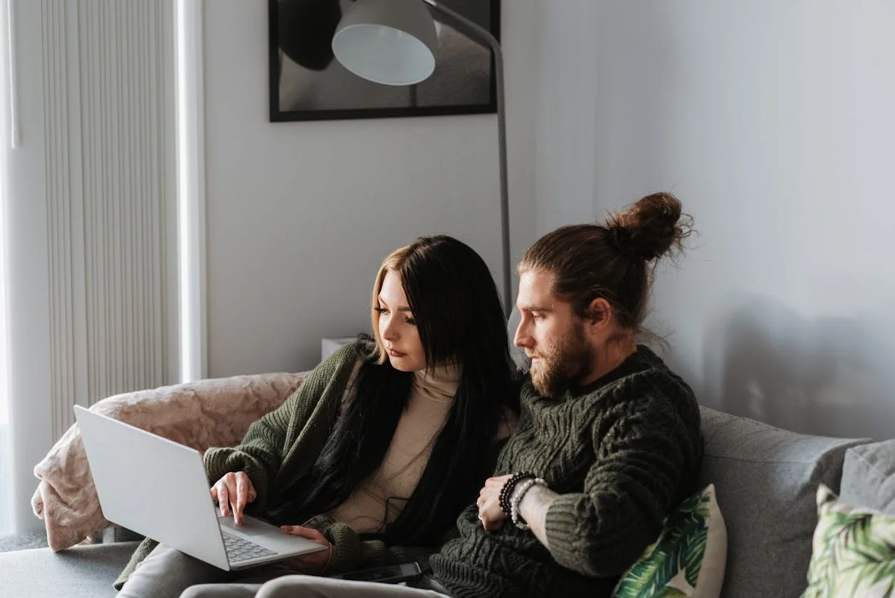 couple-surfing-internet-on-laptop-in-living-room