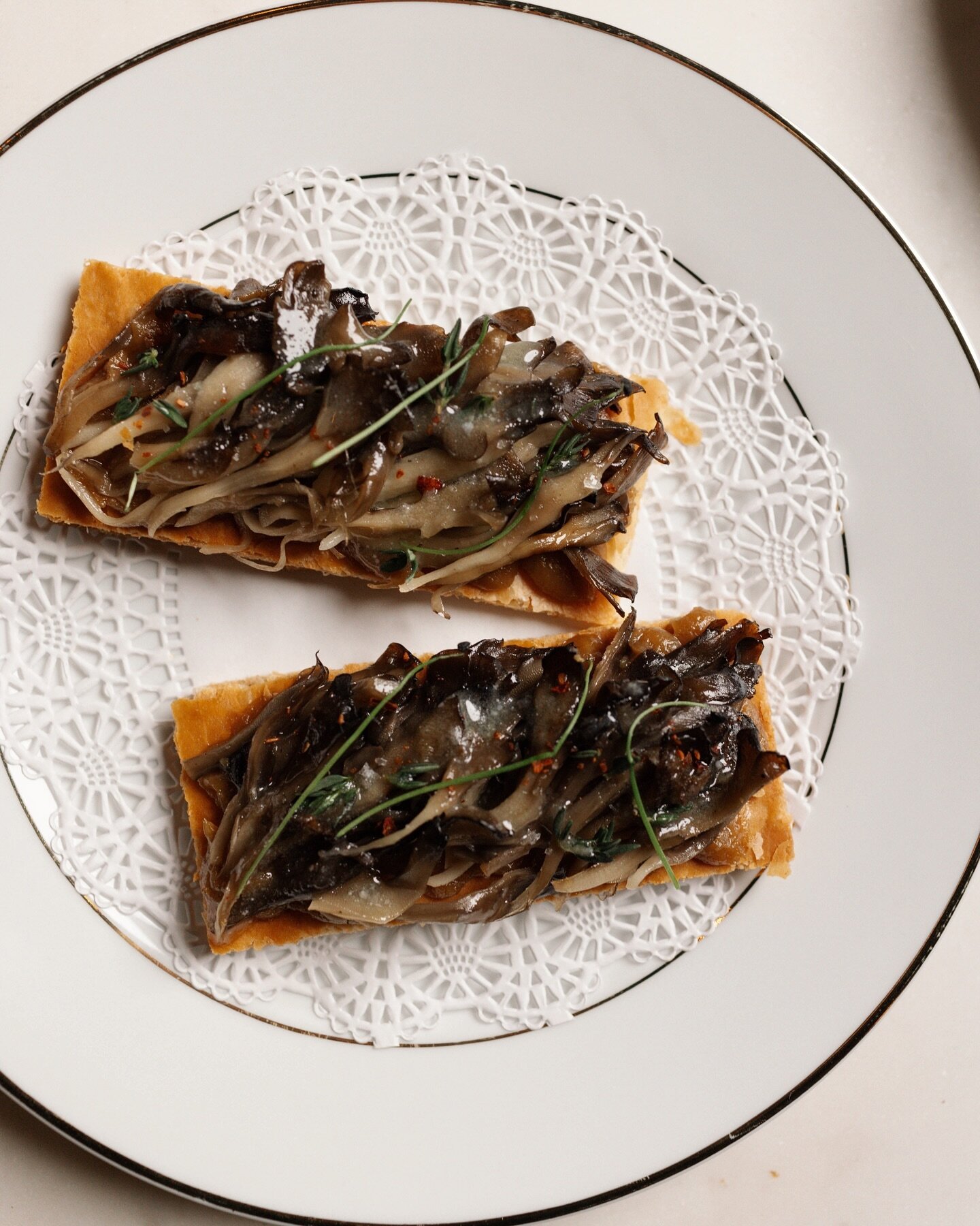 Maitake mushrooms confited, glazed and lightly grilled, and placed over smokey caramelized onions on a puff pastry tart.