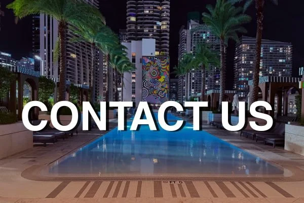 SLS LUX Hotel pool at night, with palm trees and Brickell towers. Image text: Contact us.
