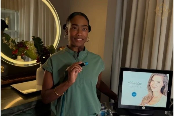 A team member holding a facial treatment handpiece beside a HydraFacial device at LUX MedSpa Brickell.